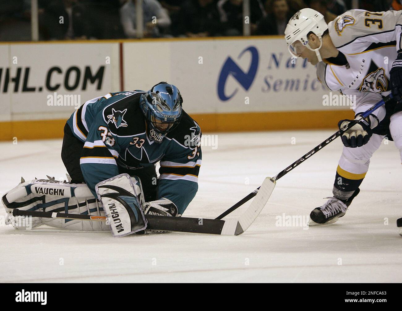 San Jose Sharks goalie Brian Boucher, left, blocks a shot on goal by Nashville Predators center Rich Peverley, right, during the first period of an NHL hockey game in San Jose, Calif.,
