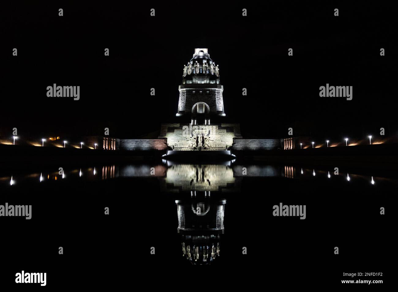 Night shot of the Monument to the Battle of the Nations 1813 in Leipzig, reflection on the water, symmetrical perspective, landmark and commemoration Stock Photo