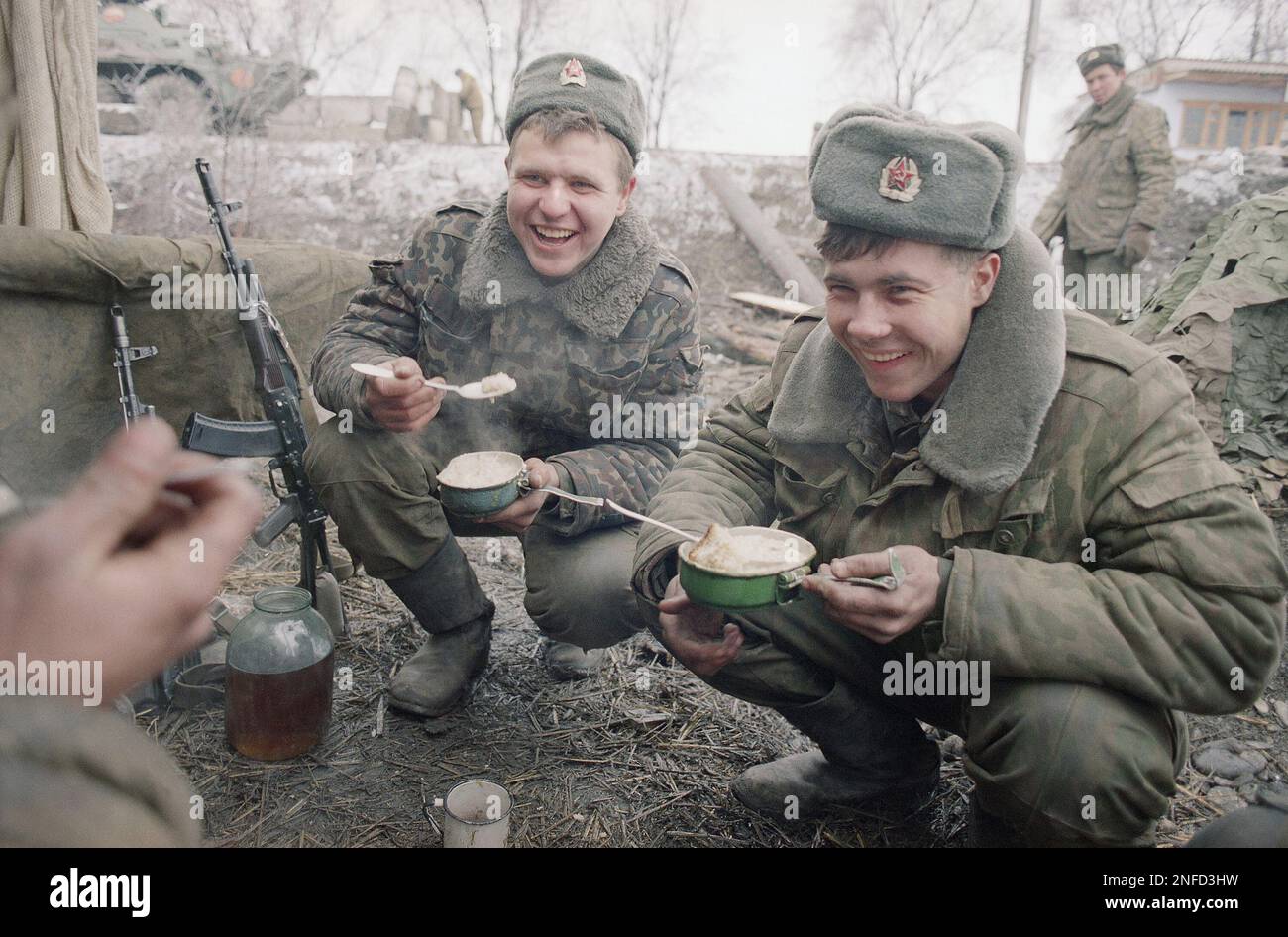 Two Russian interior ministry soldiers enjoy a meal at their positions ...