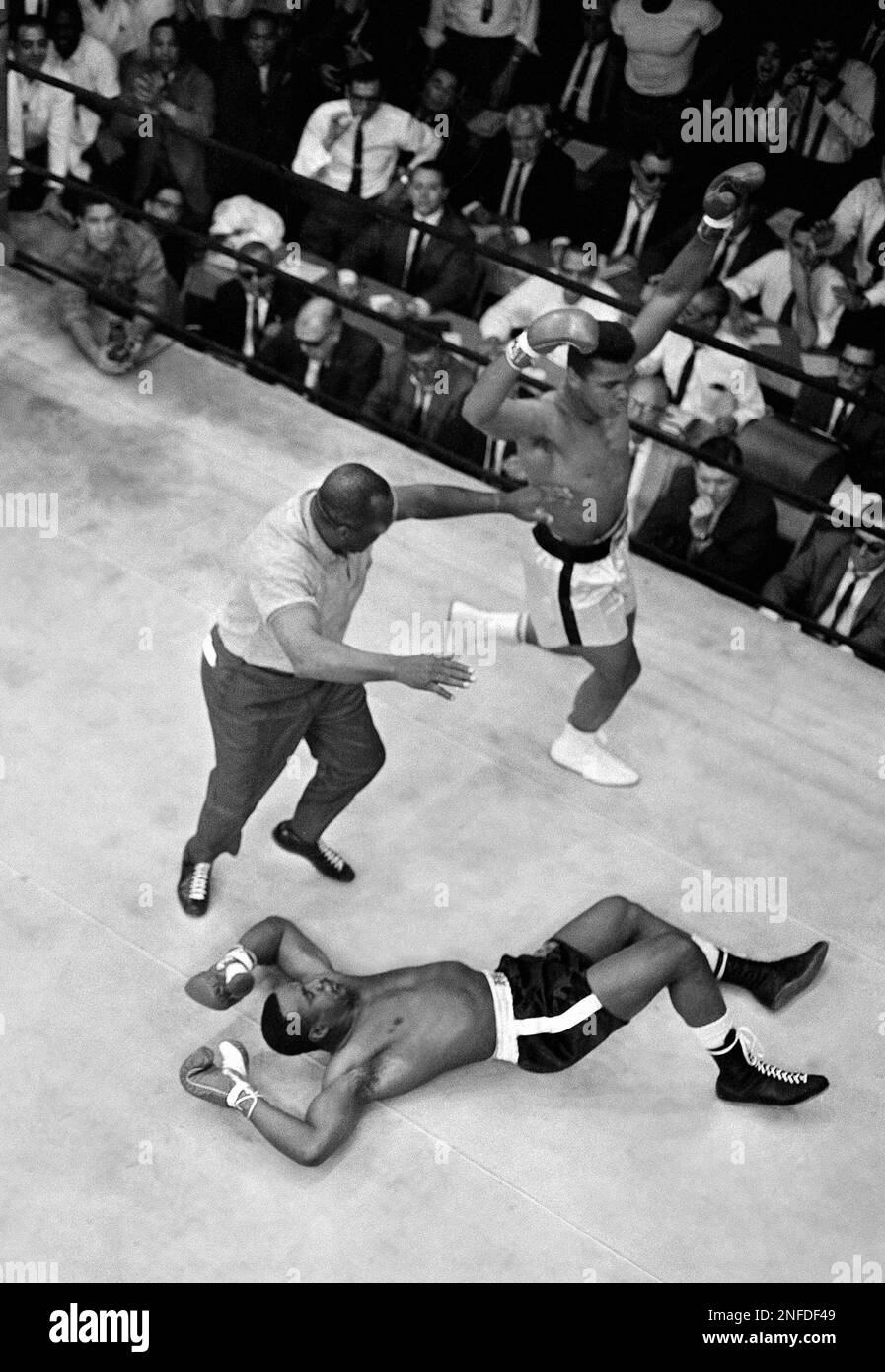 Heavyweight champion Muhammad Ali goes into a victory dance as referee