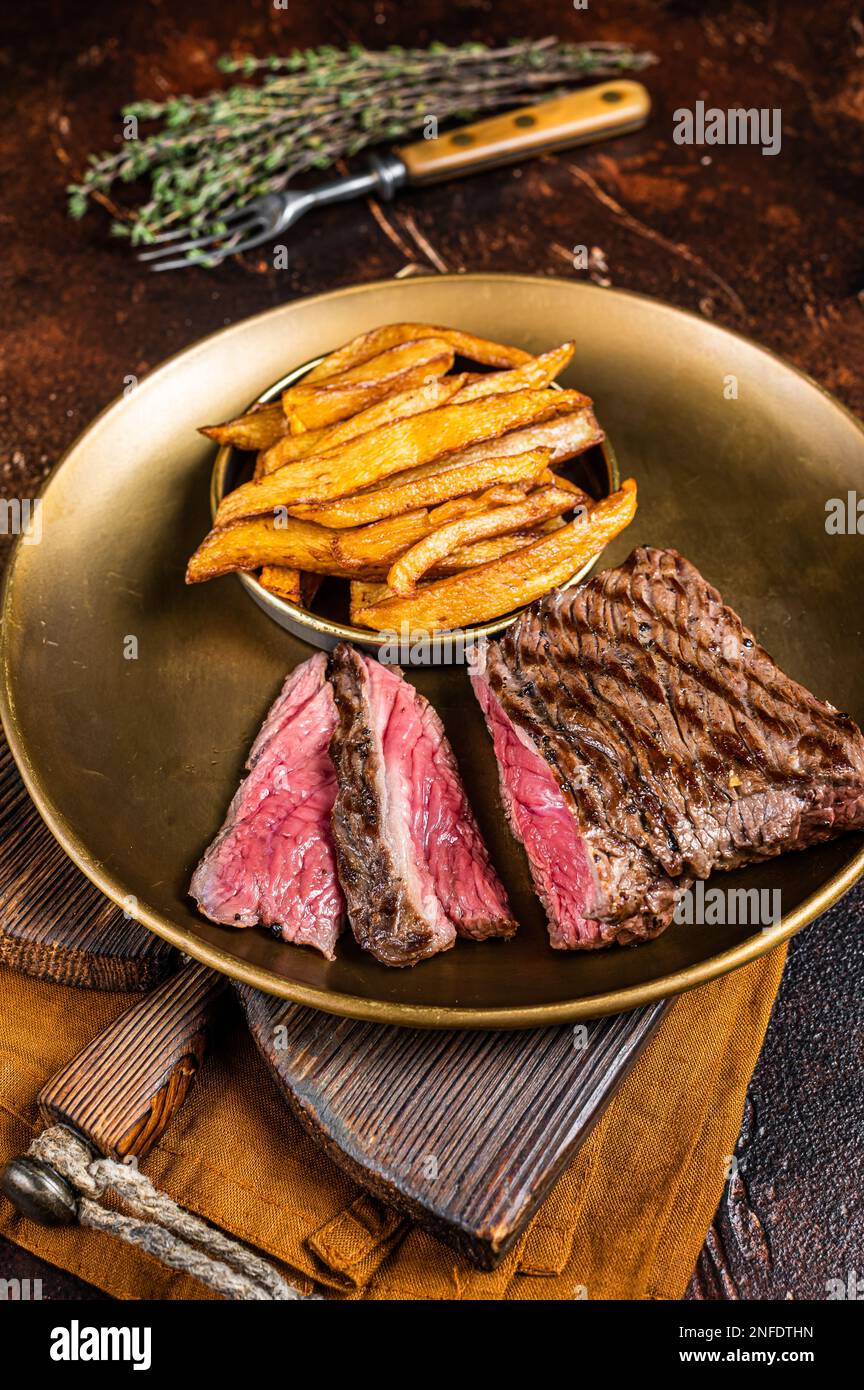 Elk steak with herbs and french fry, game meat. Dark background. Top