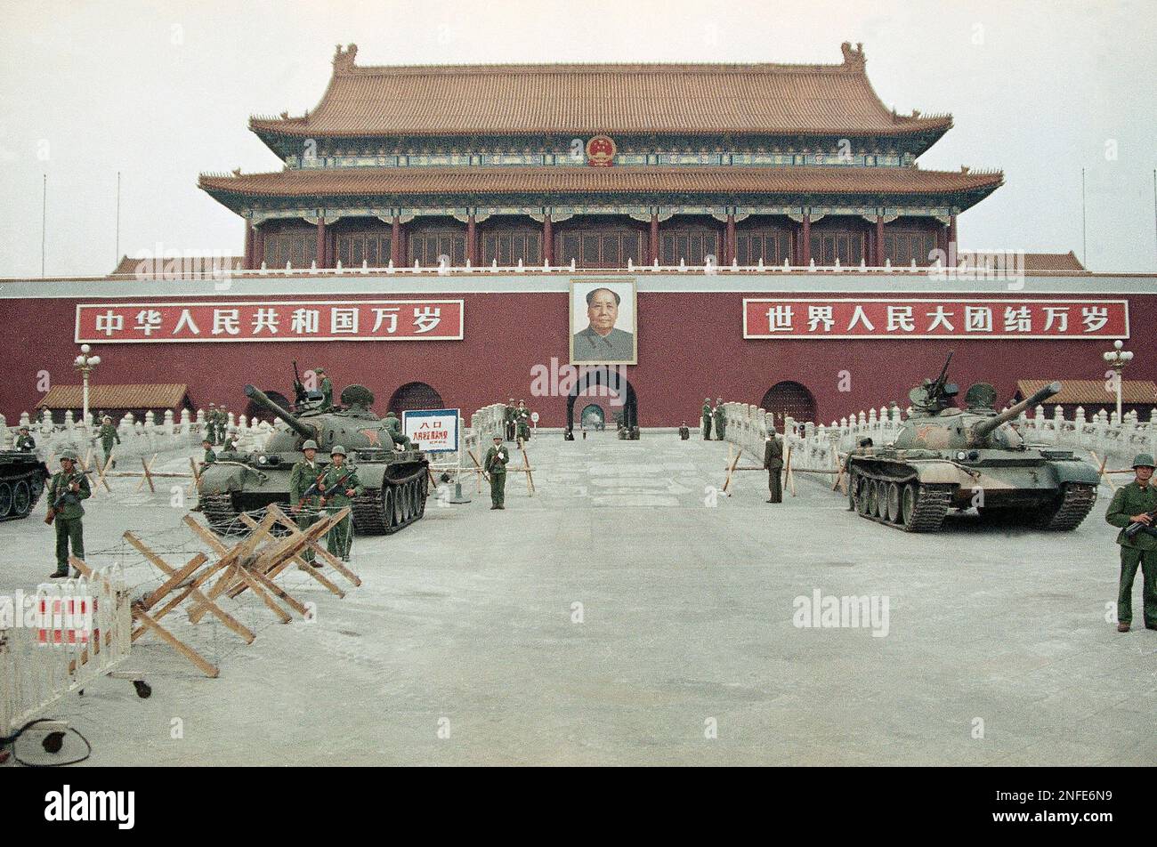 Peoples Liberation Army troops stand guard with tanks in front of ...
