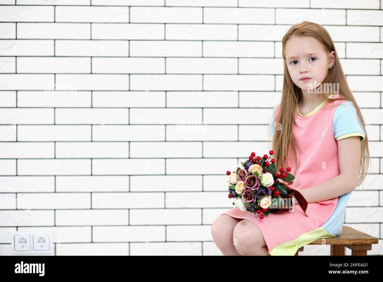 little girl is sitting on a chair and posing on the camera Stock Photo ...