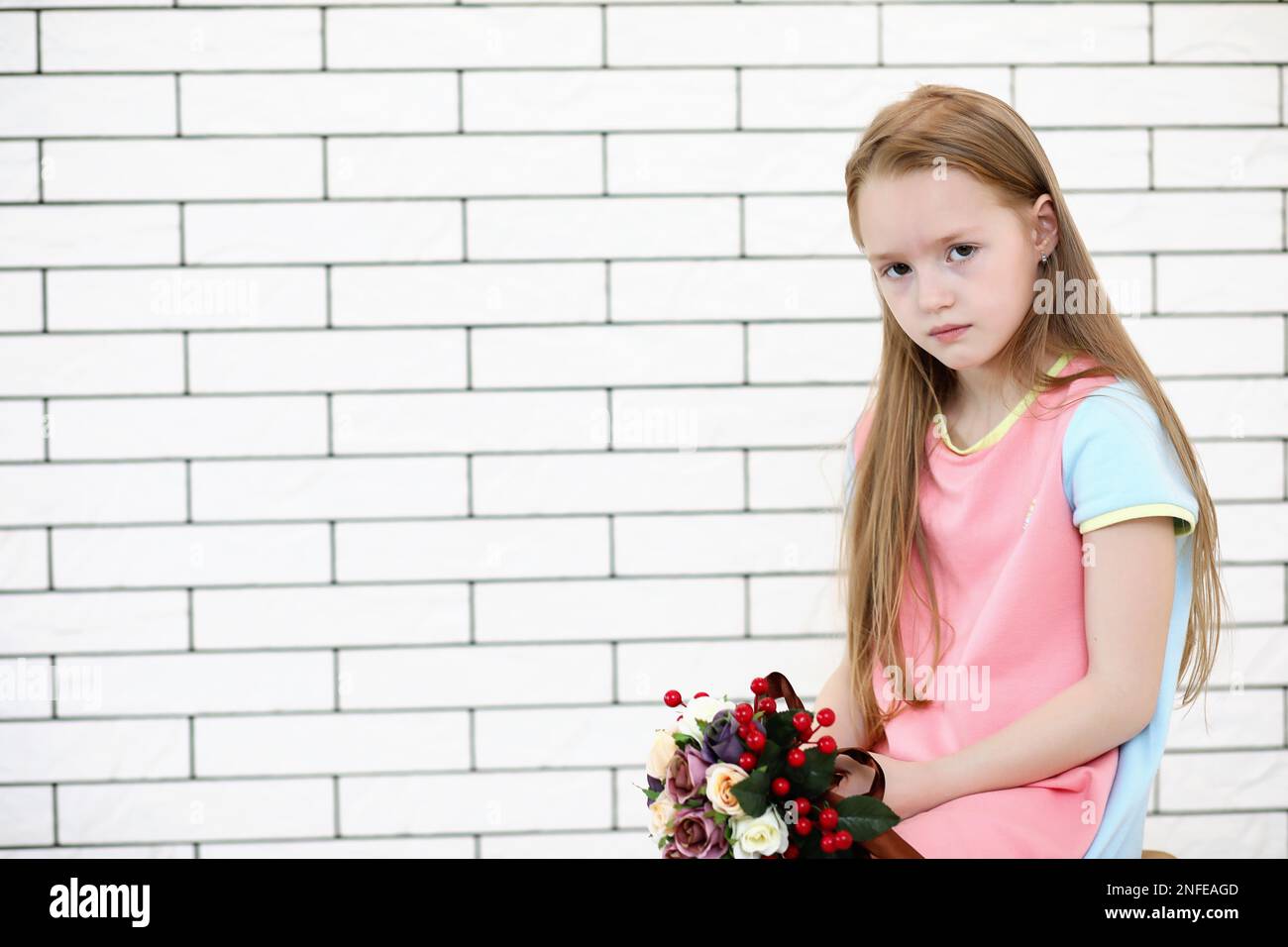 little girl is sitting on a chair and posing on the camera Stock Photo ...
