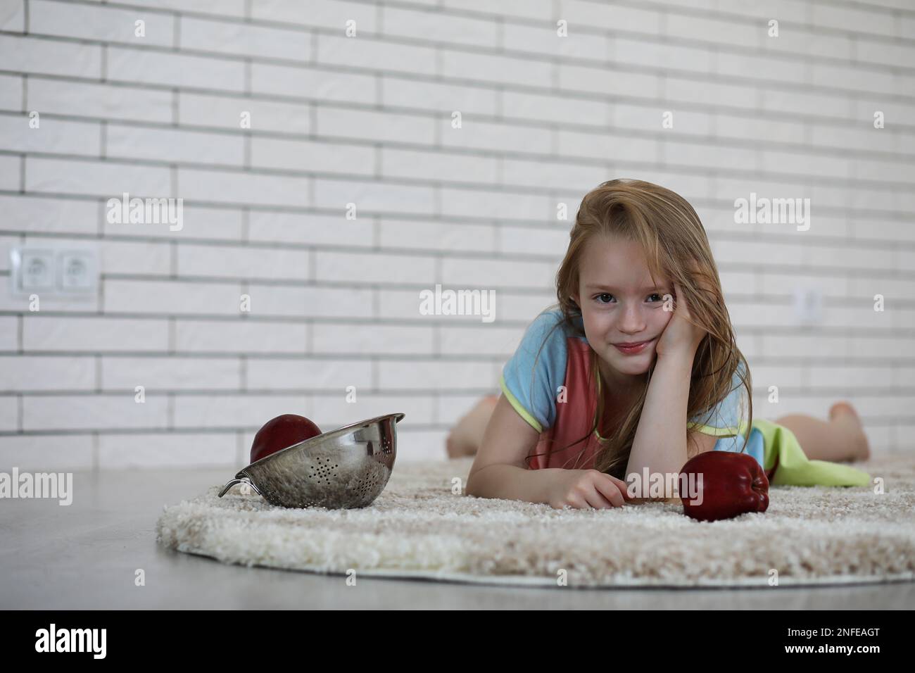 little girl lies on the floor and eats an apple Stock Photo - Alamy