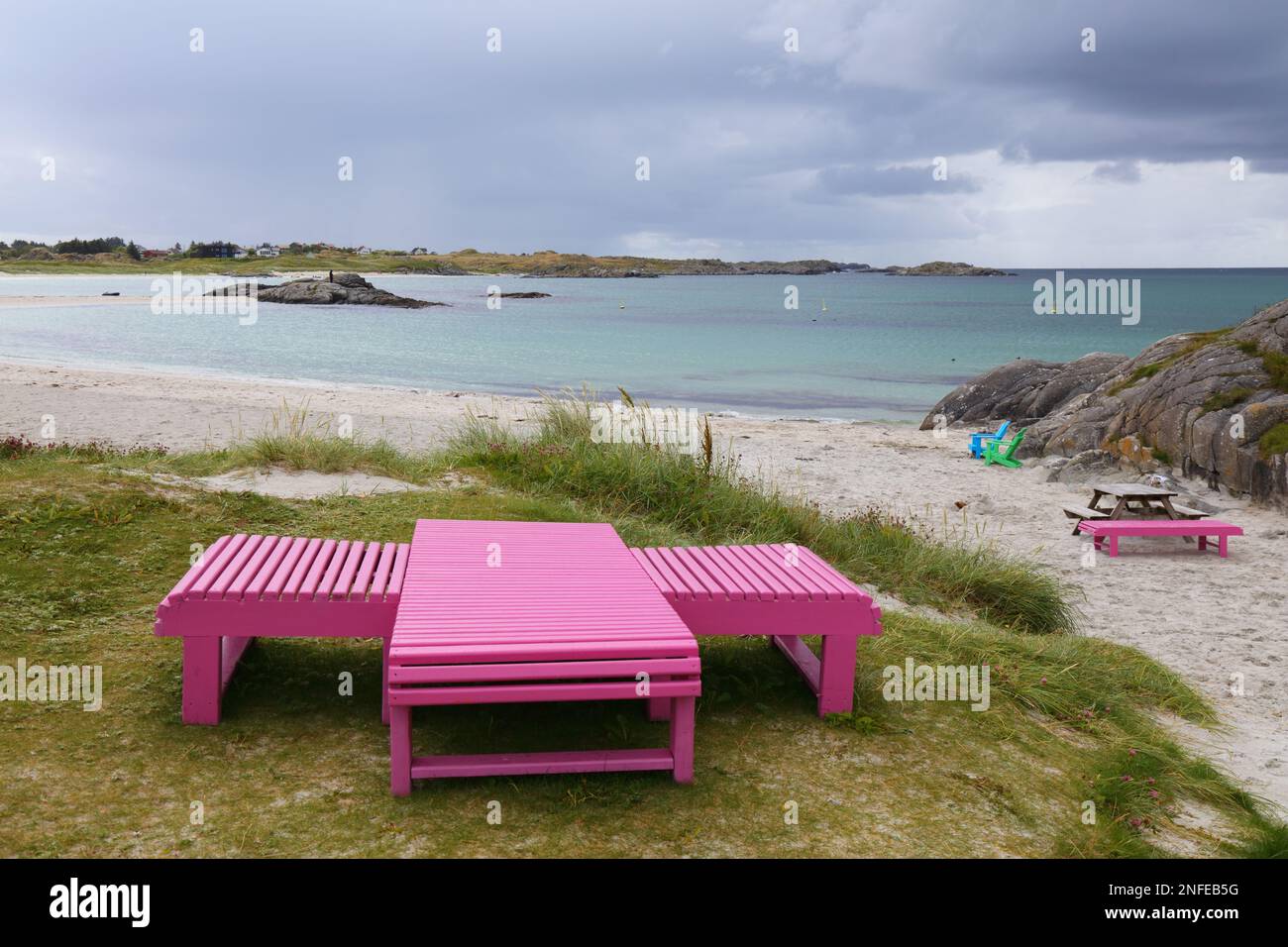 Norway beach in summer. Akrasanden beach public wooden benches and sunchairs near Akrehamn. Karmoy island. Stock Photo