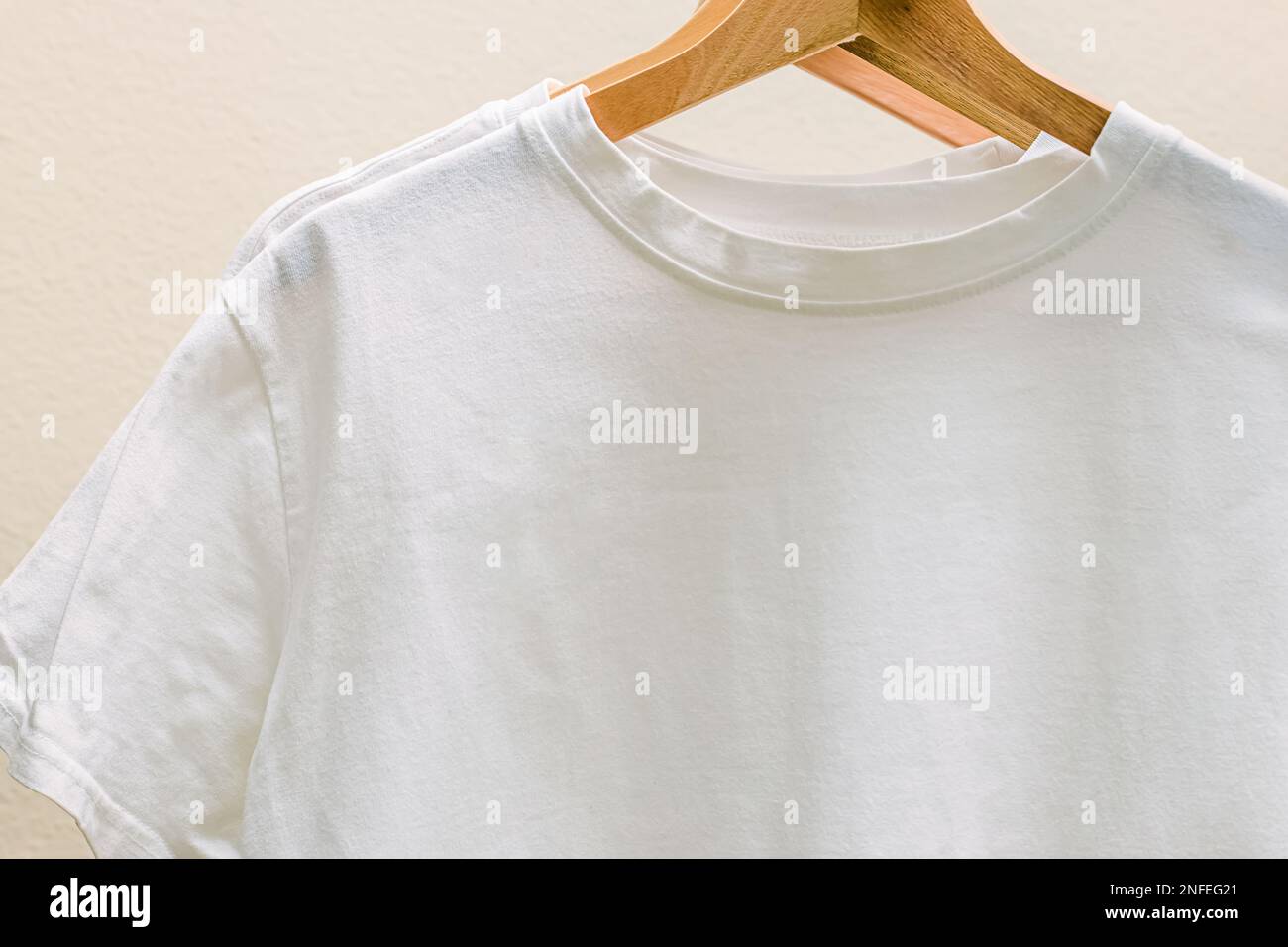 White cotton t-shirts on the hangers close-up. Place for text Stock Photo