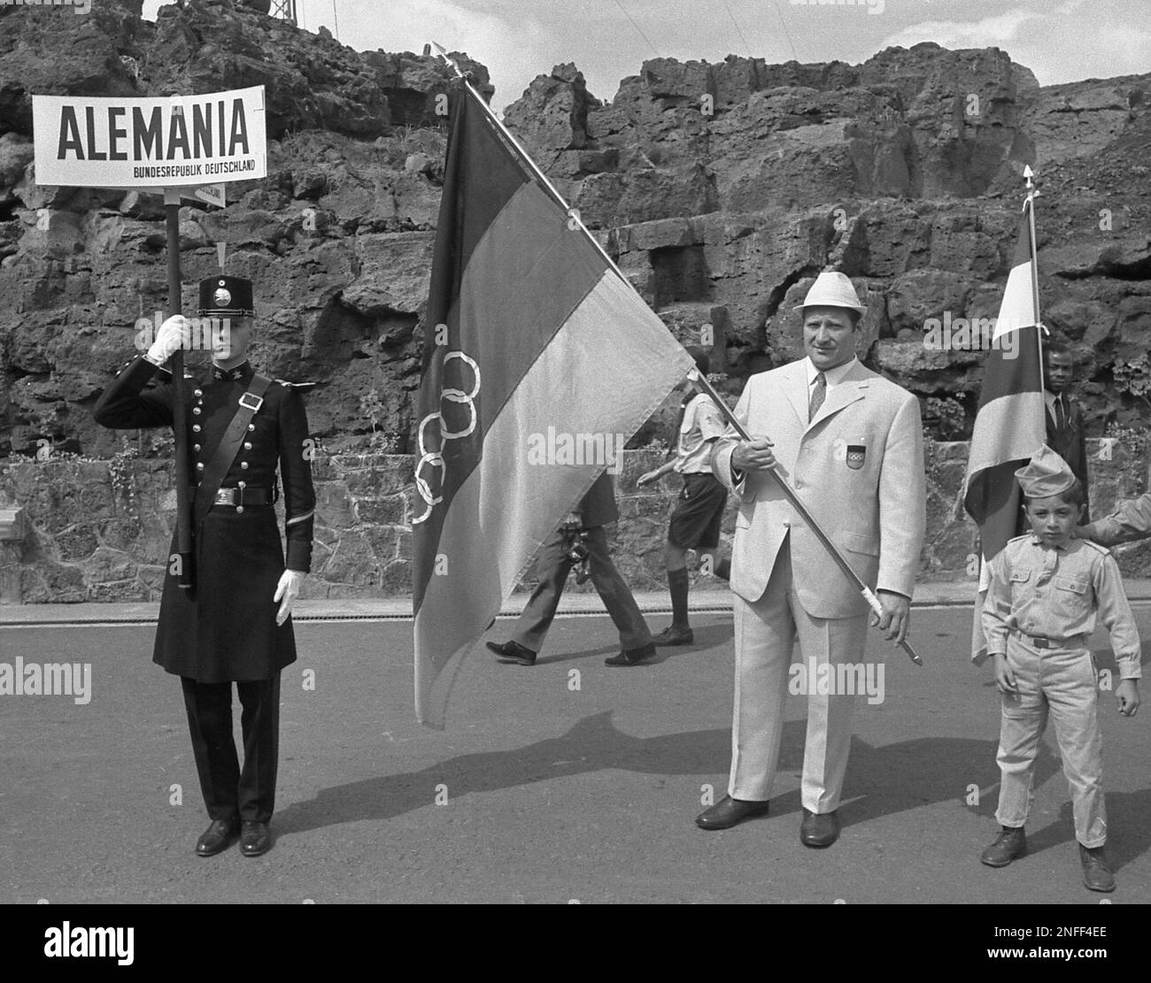 The uniformed West German sign bearer, flag carrier and a boy are pictured during the opening of