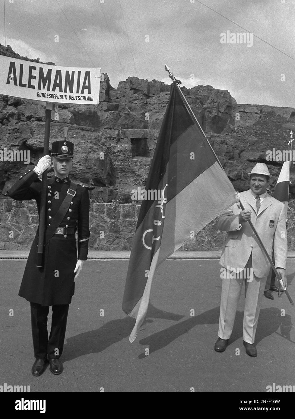 The uniformed West German sign bearer and flag carrier are pictured during the opening of the