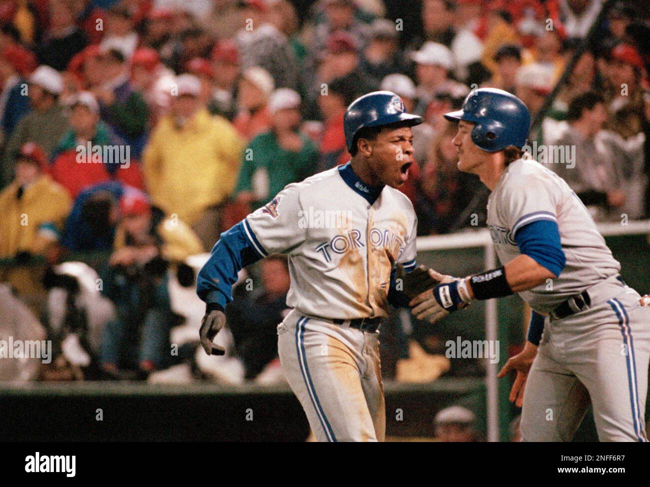 Toronto Blue Jays' Rickey Henderson, left, celebrates with teammate Pat  Borders after scoring on a Devon White triple in the eighth inning of Game 4  of the World Series, Oct. 20, 1993