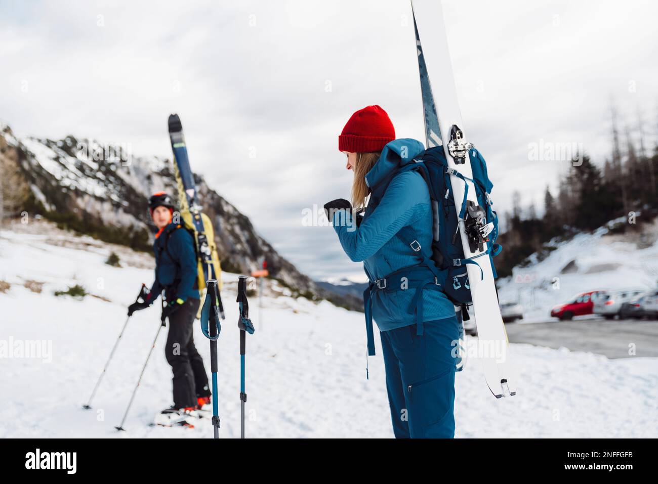 Couple of ski tourers carrying their skies tied up on a backpack Stock Photo