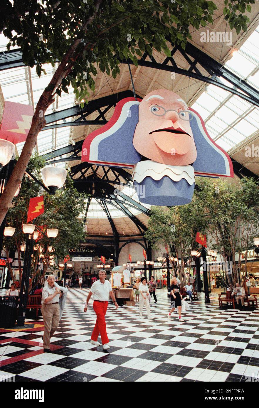 Shoppers stroll under a huge head of Ben Franklin in early July 1990 at