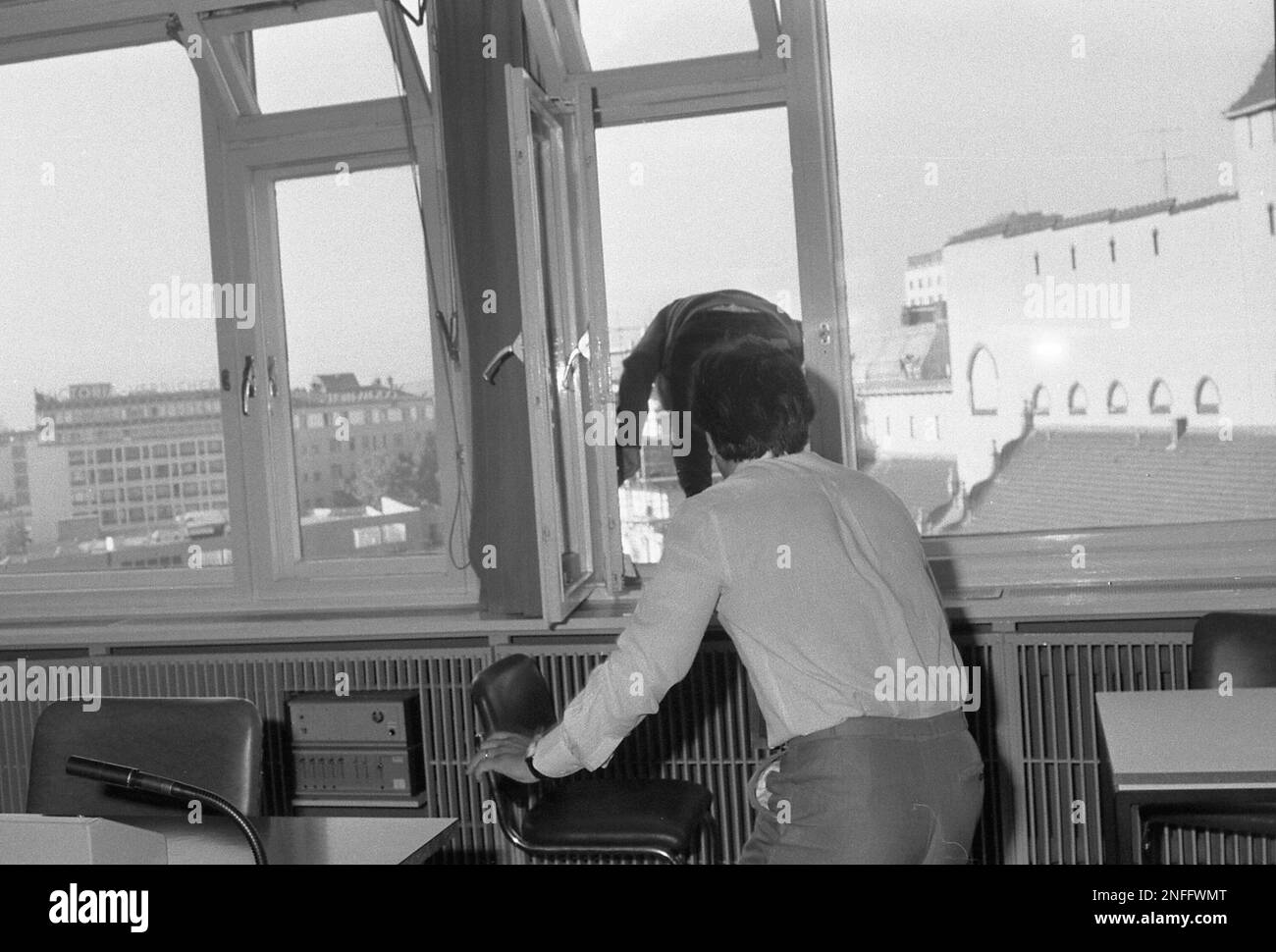 Turkish national Cemal Altun, 23, seeking political asylum in West Berlin, who suddenly got up from his chair is seen at the open window climbing standing on the sill at the opening of his asylum hearing in a court in West Berlin, West Germany, Tuesday August 30, 1983. Just a few seconds after this image was taken the young man jumped down from the sixth floor of the building committing suicide. EDS note: Image 9 of a set of 16. (AP Photo/Elke Bruhn-Hoffmann) Stock Photo