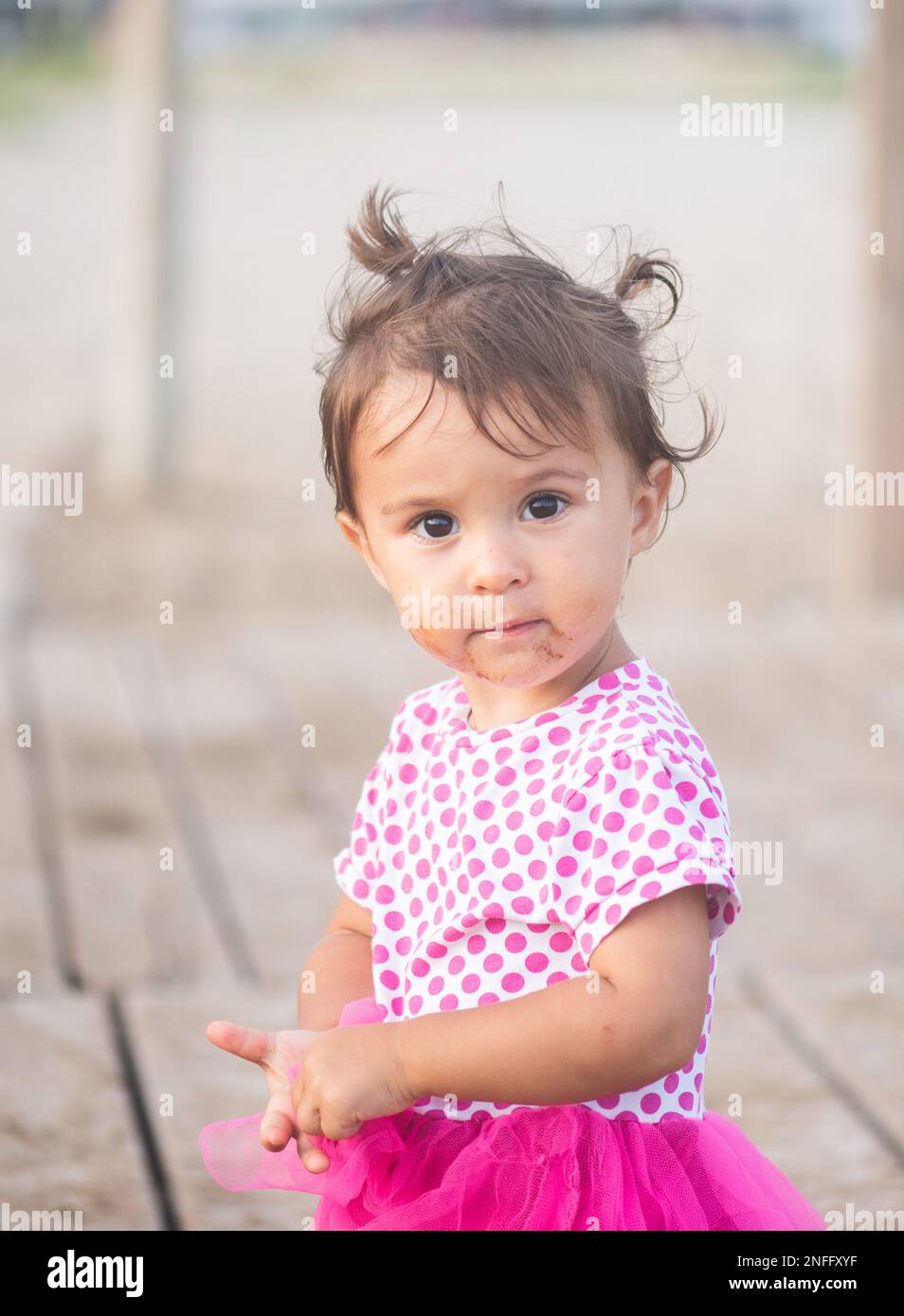 Portrait of cute little girl with pink dress on the beach Stock Photo