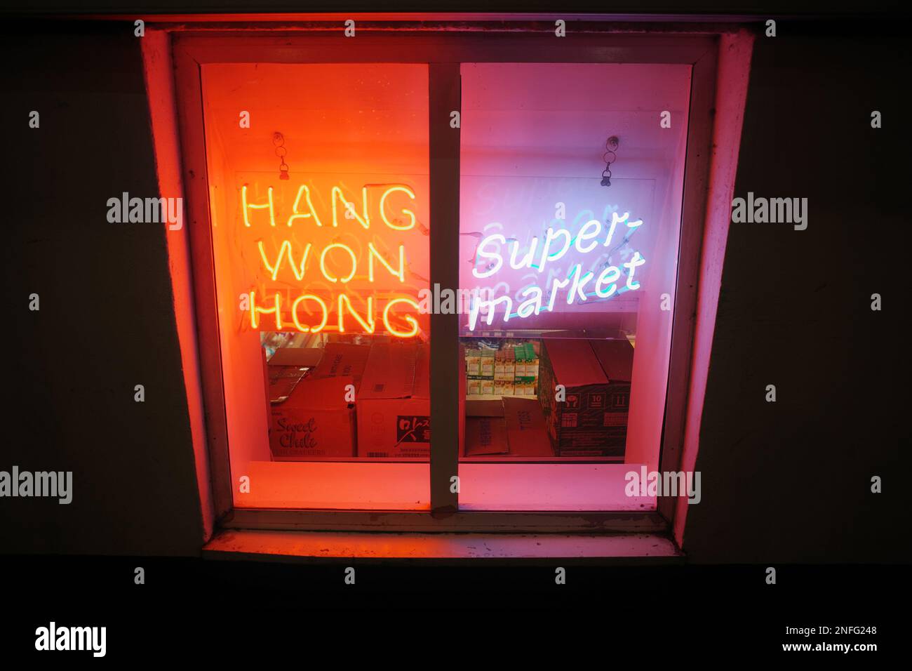 Hang Won Hong Supermarket, Chinatown, Manchester, UK. Lit neon signs at night, colourful, window Stock Photo