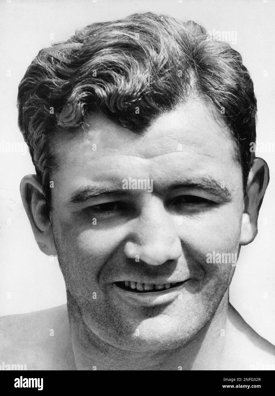 Heavyweight champion James J. Braddock smiles from behind his face of