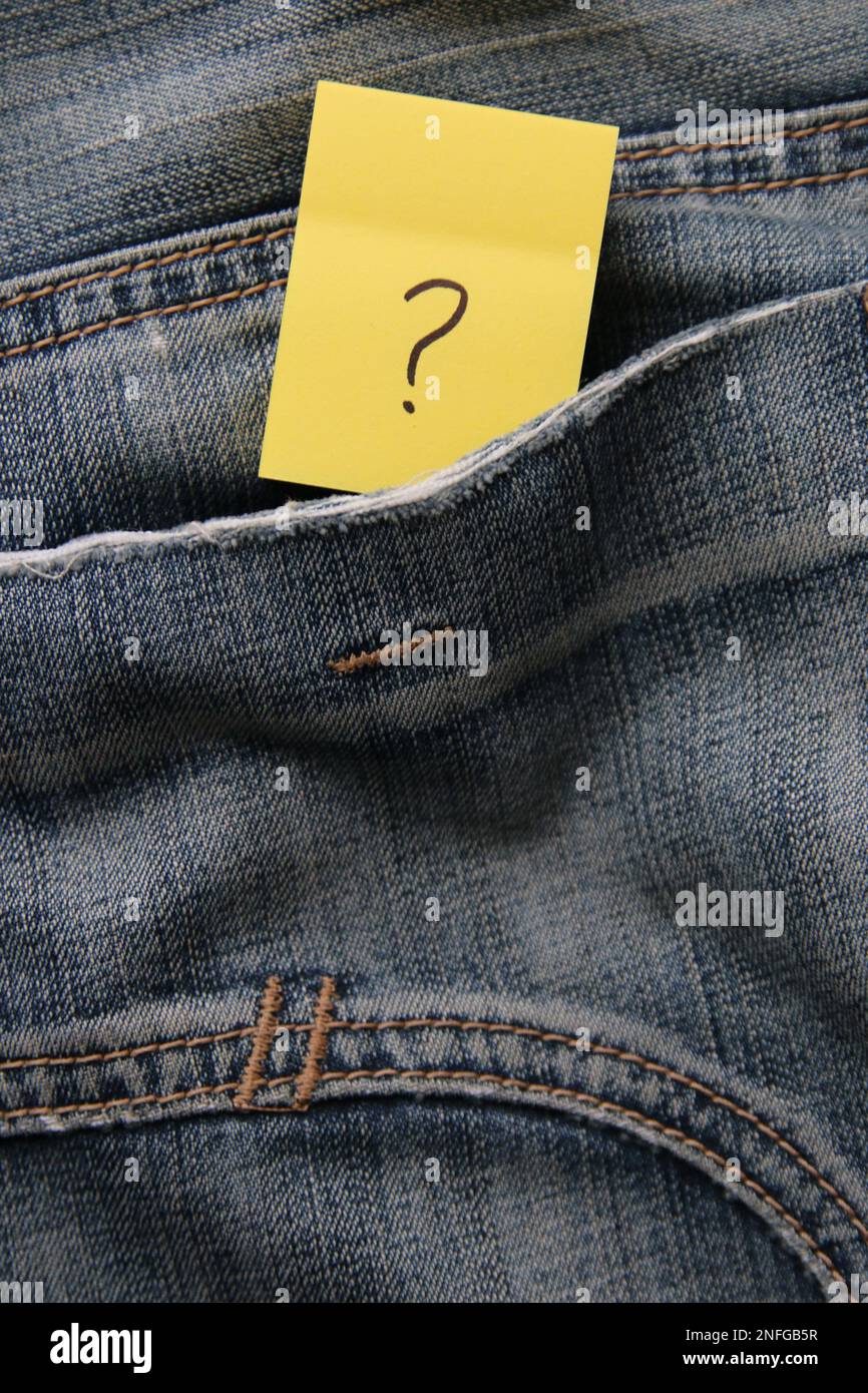 A question mark on a paper tag in a jeans pocket. Question mark on