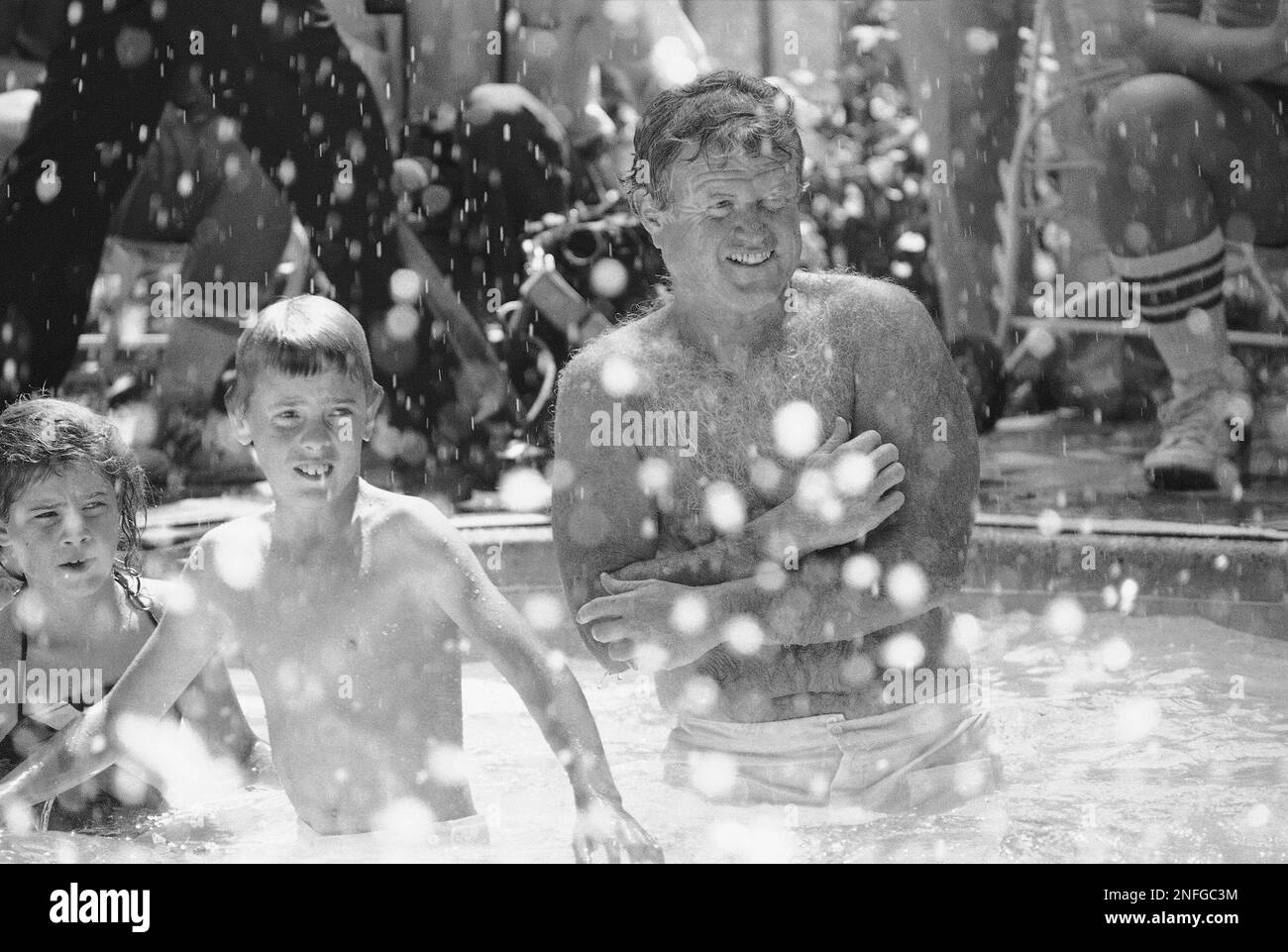 Sen. Edward Kennedy, D-Mass. shouts encouragement to members of the Boston  Southern Babe Ruth baseball team from Boston as they swim in the Senator's  pool, Wednesday, August 18, 1982 in Mclean, Va.