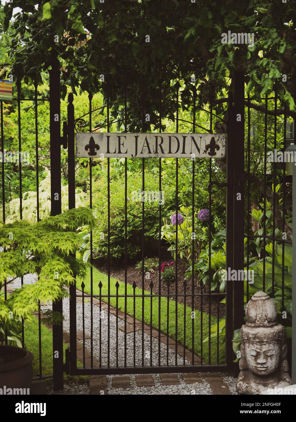 A vertical shot of a metal gate with the French words 'Le Jardin