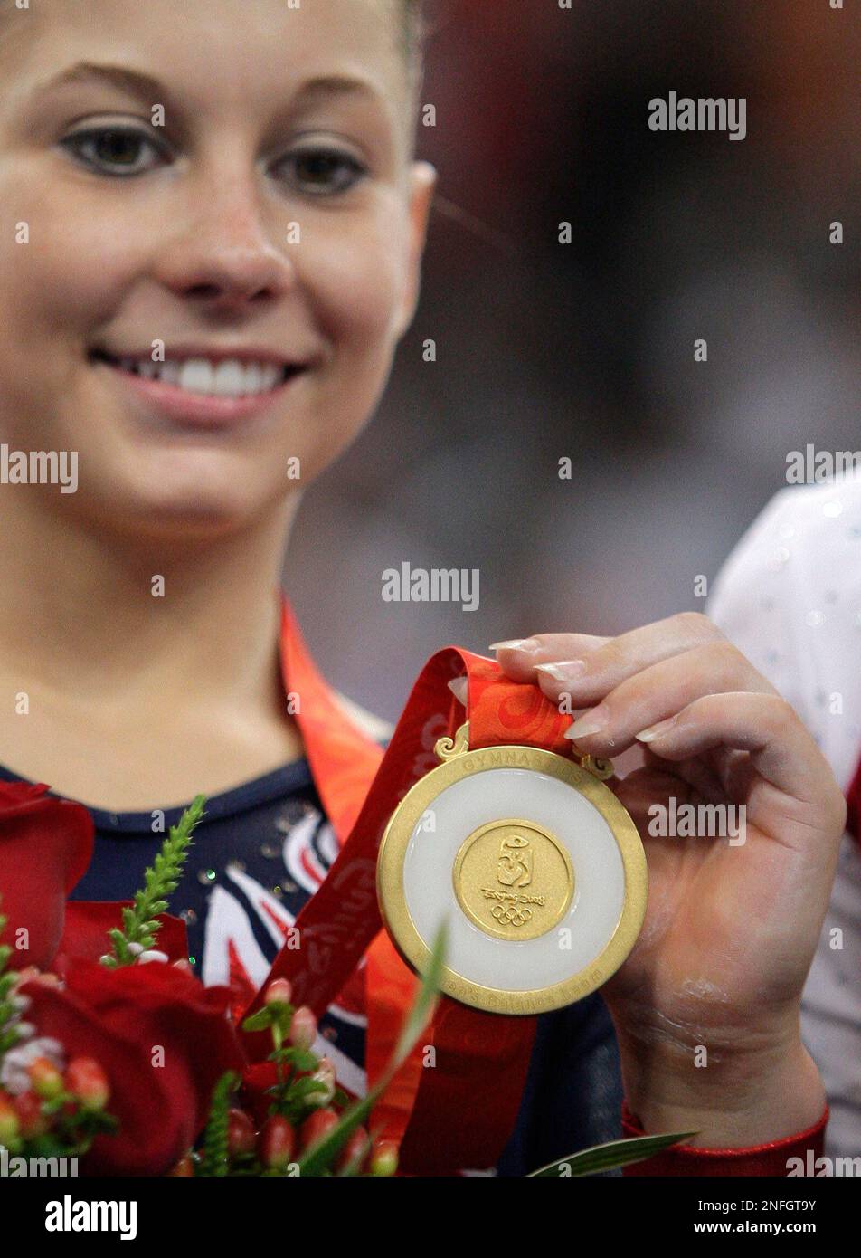U.S. gymnast Shawn Johnson poses with her gold medal on the podium for
