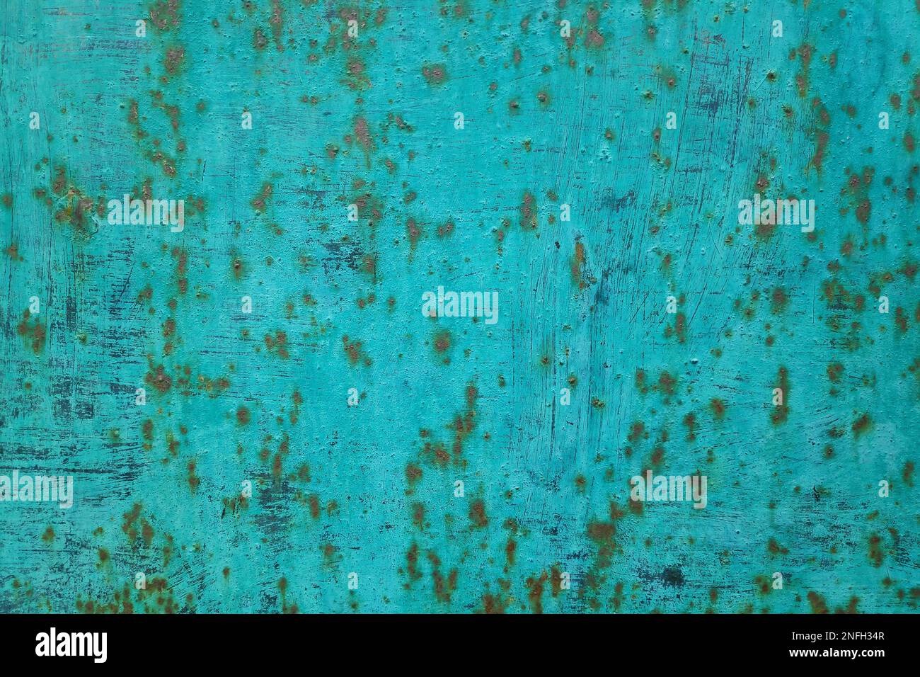 Full frame close-up on a rusty metal plate painted in turquoise. Stock Photo