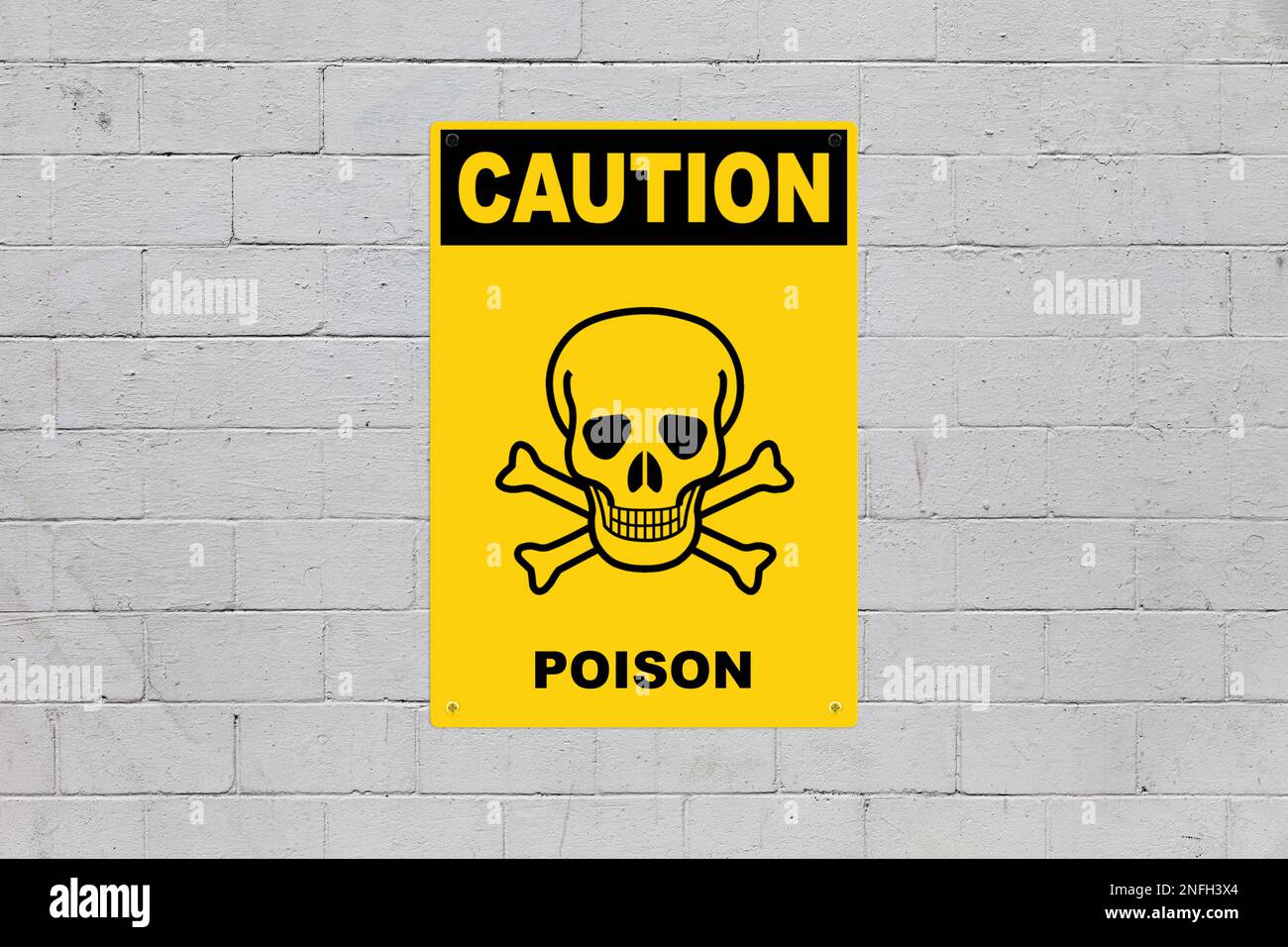 Yellow warning sign screwed to a brick wall to warn about a threat. In the middle of the panel, there is a skull and bones symbol and the message is s Stock Photo