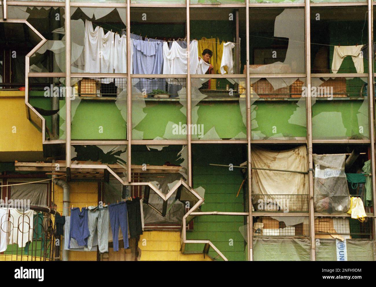 A Sarajevo woman hangs her laundry on her war-torn balcony downtown Sarajevo, Yugoslavia Sunday, May 21, 1995. Battlefields throughout Bosnia Herzegovina remained relatively quiet Sunday. (AP Photo/Jerome Delay) Stock Photo