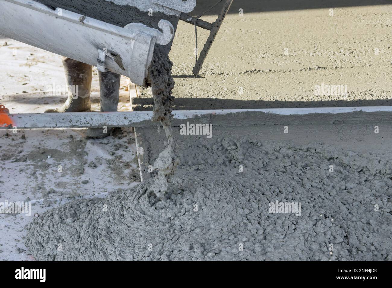 On building site concrete mixing truck is pouring concrete for pavement