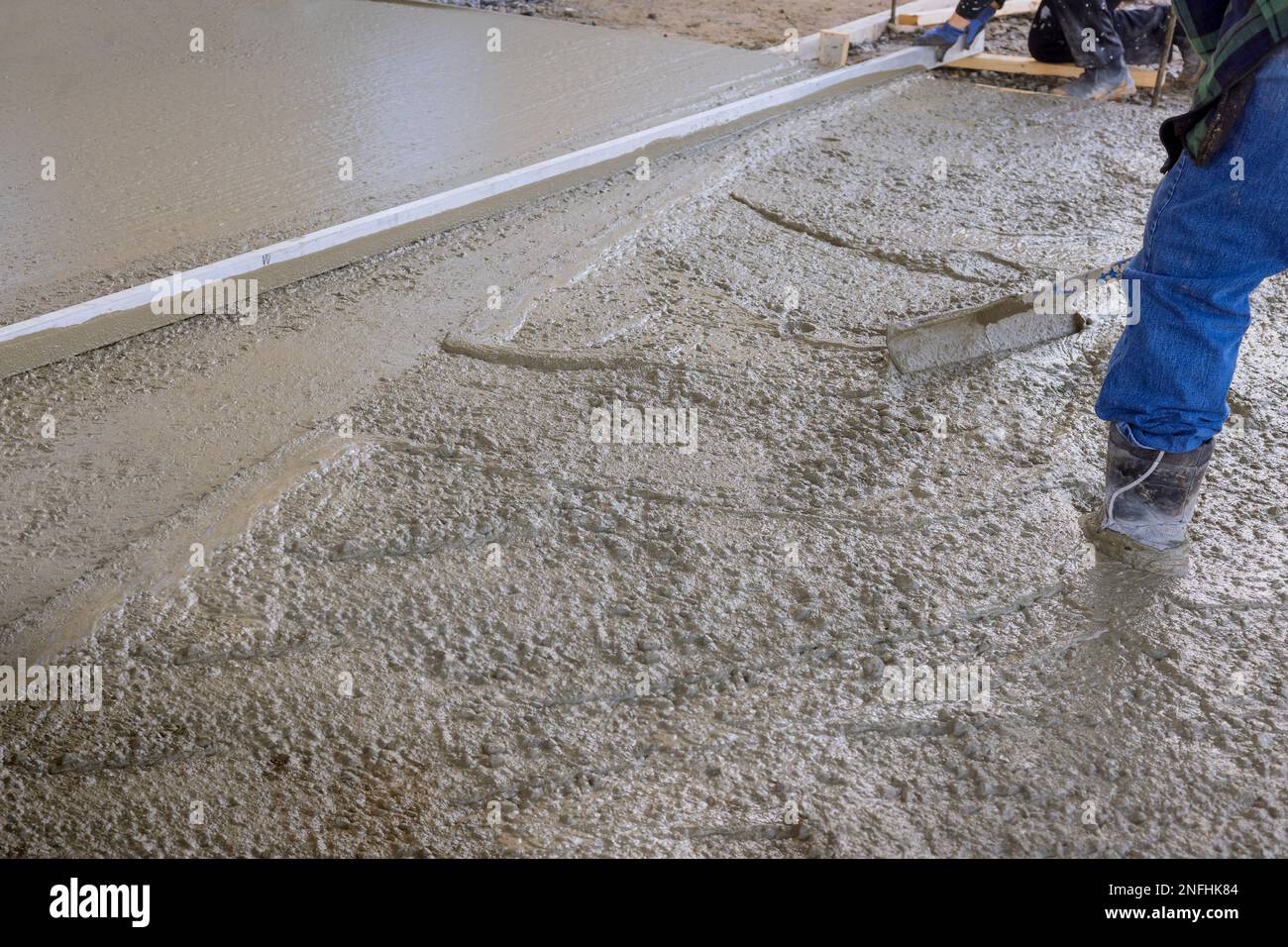 Concrete was poured on wet cement sidewalk by construction worker using