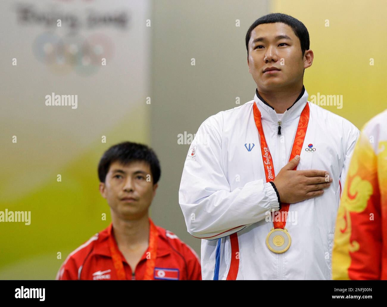 Gold medalist Jin Jongoh, from South Korea, right, stands for the