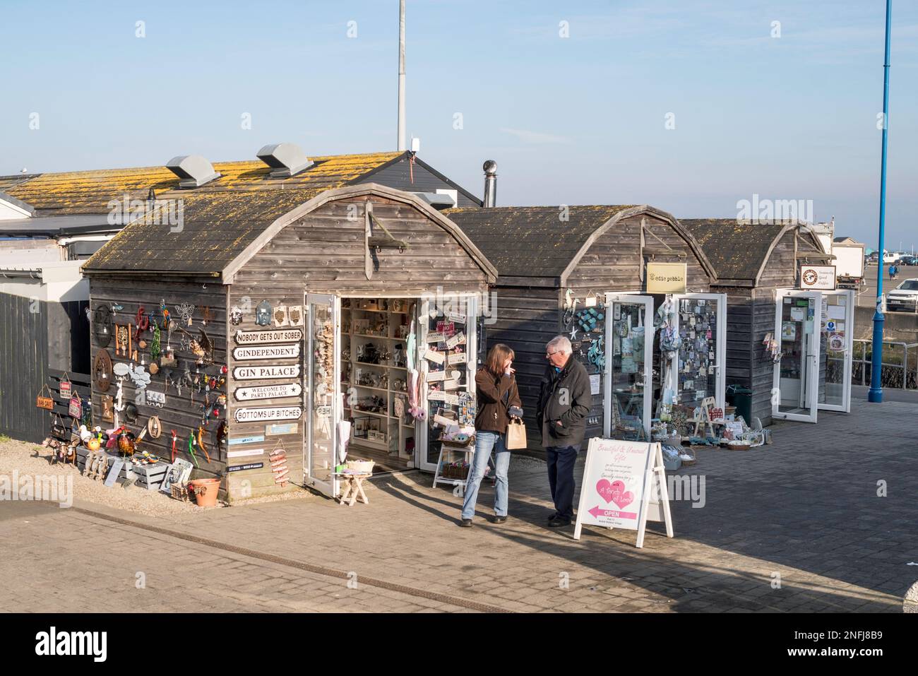 A couple outside shops in Amble harbour village, Northumberland, England, UK Stock Photo