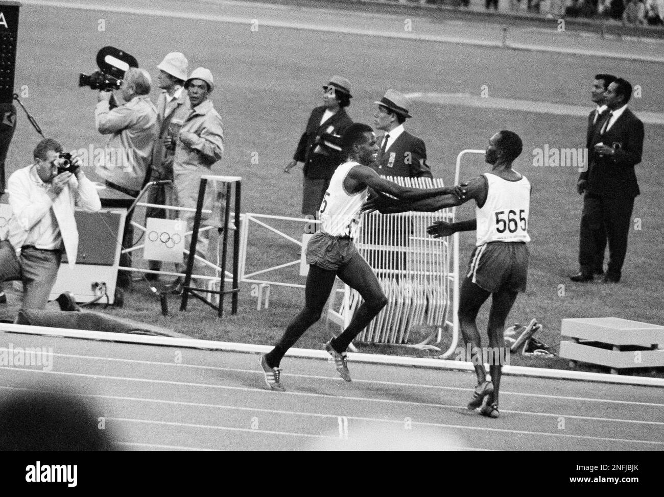 Kipchoge Keino (565), Kenya's famous distance runner, rushes out to embrace his teammate
