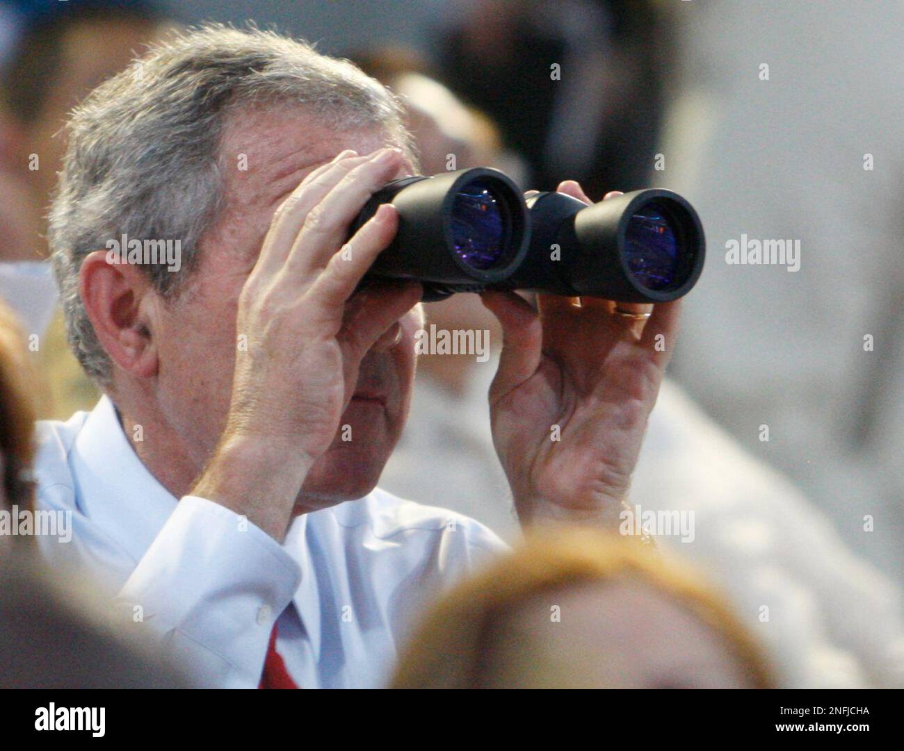 U.S. President George Bush uses binoculars to watch the Beijing 2008 Summer Olympics opening ceremony in Beijing, Friday, Aug. 8, 2008. (AP Photo/Charles Dharapak, Pool) Stock Photo