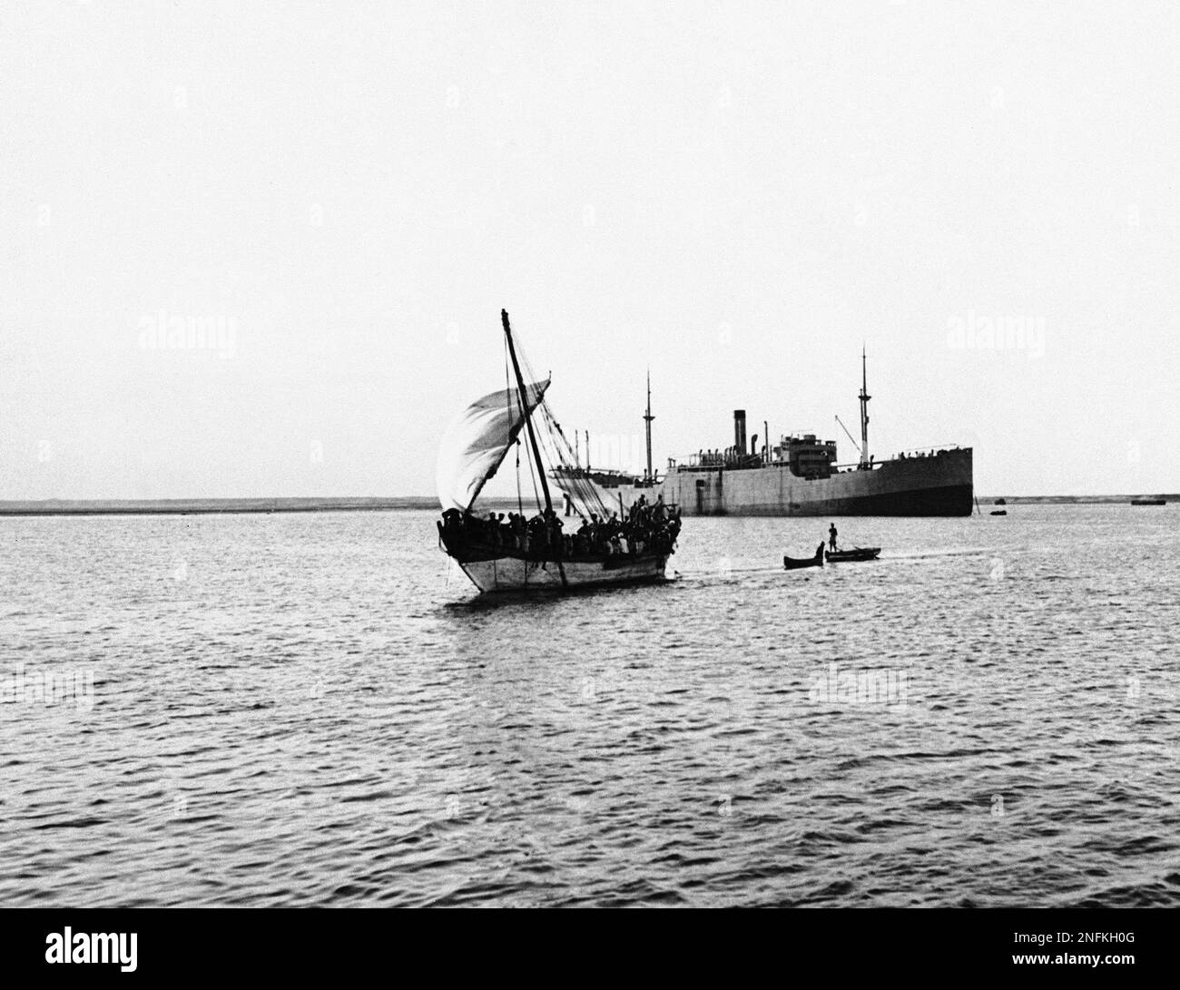 A Boatload of workers Head for shore in A sail- Equipped Boat After ...