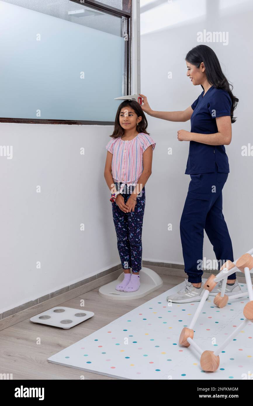 Paediatrician checking a child's height in her medical office Stock Photo