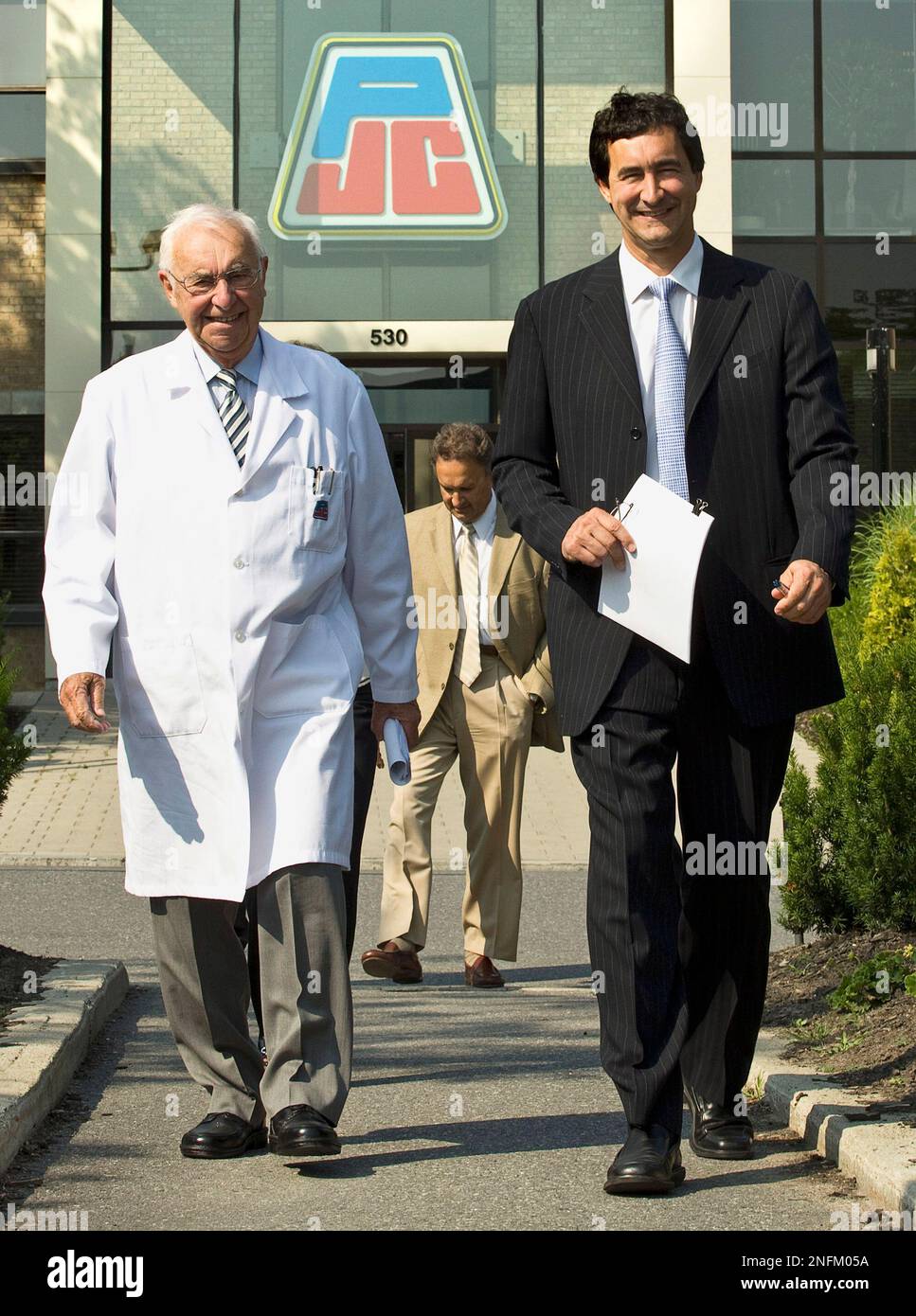 Jean Coutu, left, chairman of the board and founder of Jean Coutu Inc., and  his son Francois Coutu, president and CEO, walk to the retail drugstore's  annual meeting, Tuesday, July 8, 2008
