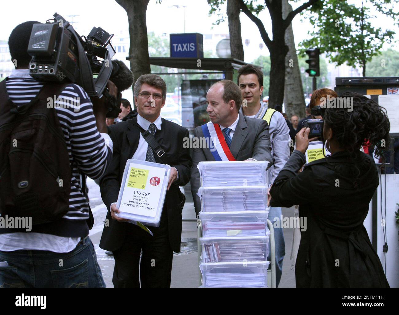Stephan Oberreit, Director of Amnesty International in France, center left,  and Jean Jaques Urvoas, a French member of parliament, center right, carry  boxes containing 116,467 signatures demanding the release of dissident  prisoners