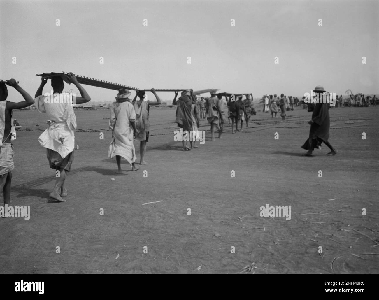 U.S. Army engineers, with native labourers, laying the metal landing