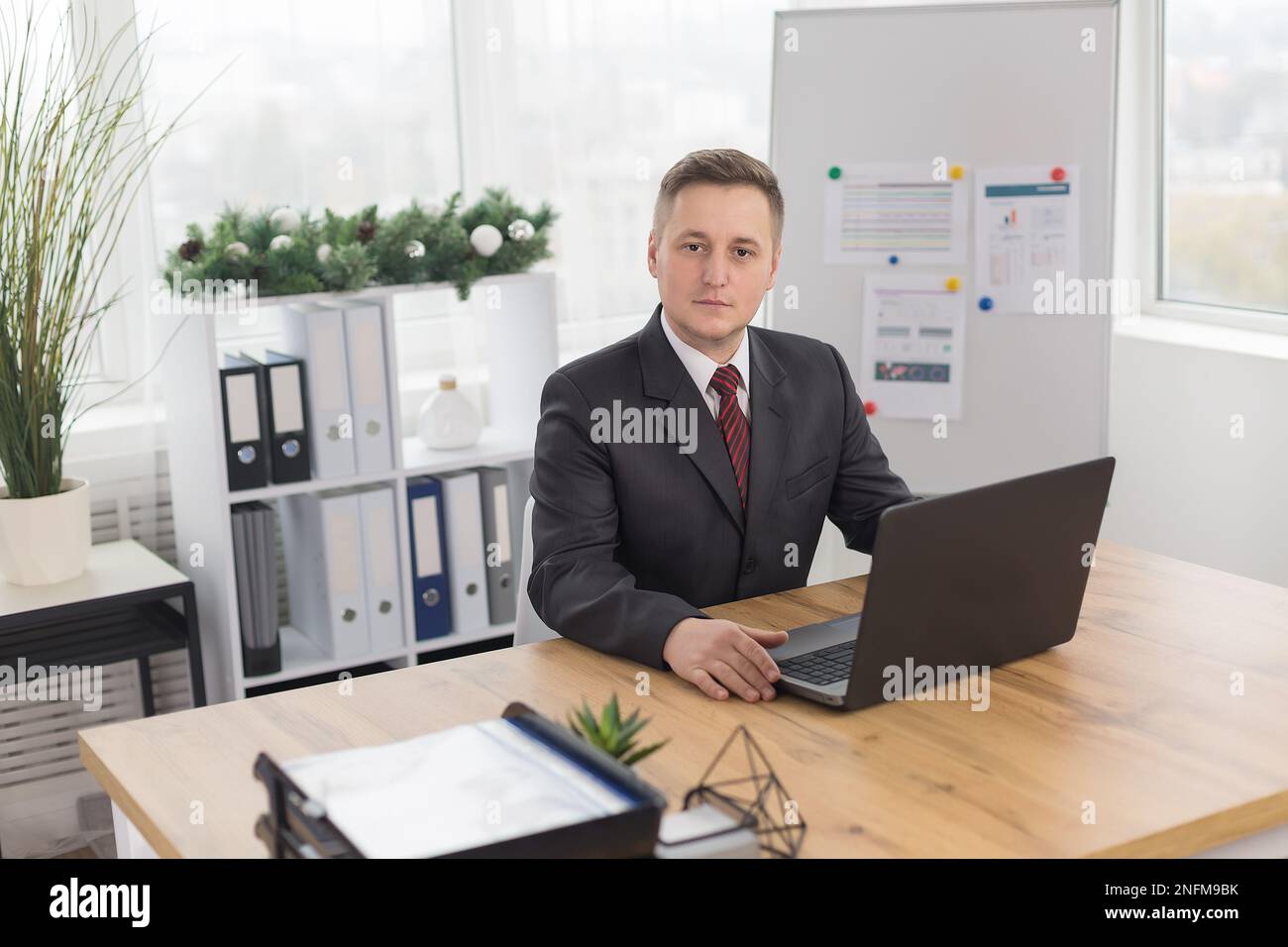 man in the office at the Desk. office worker in office with Christmas decor Stock Photo