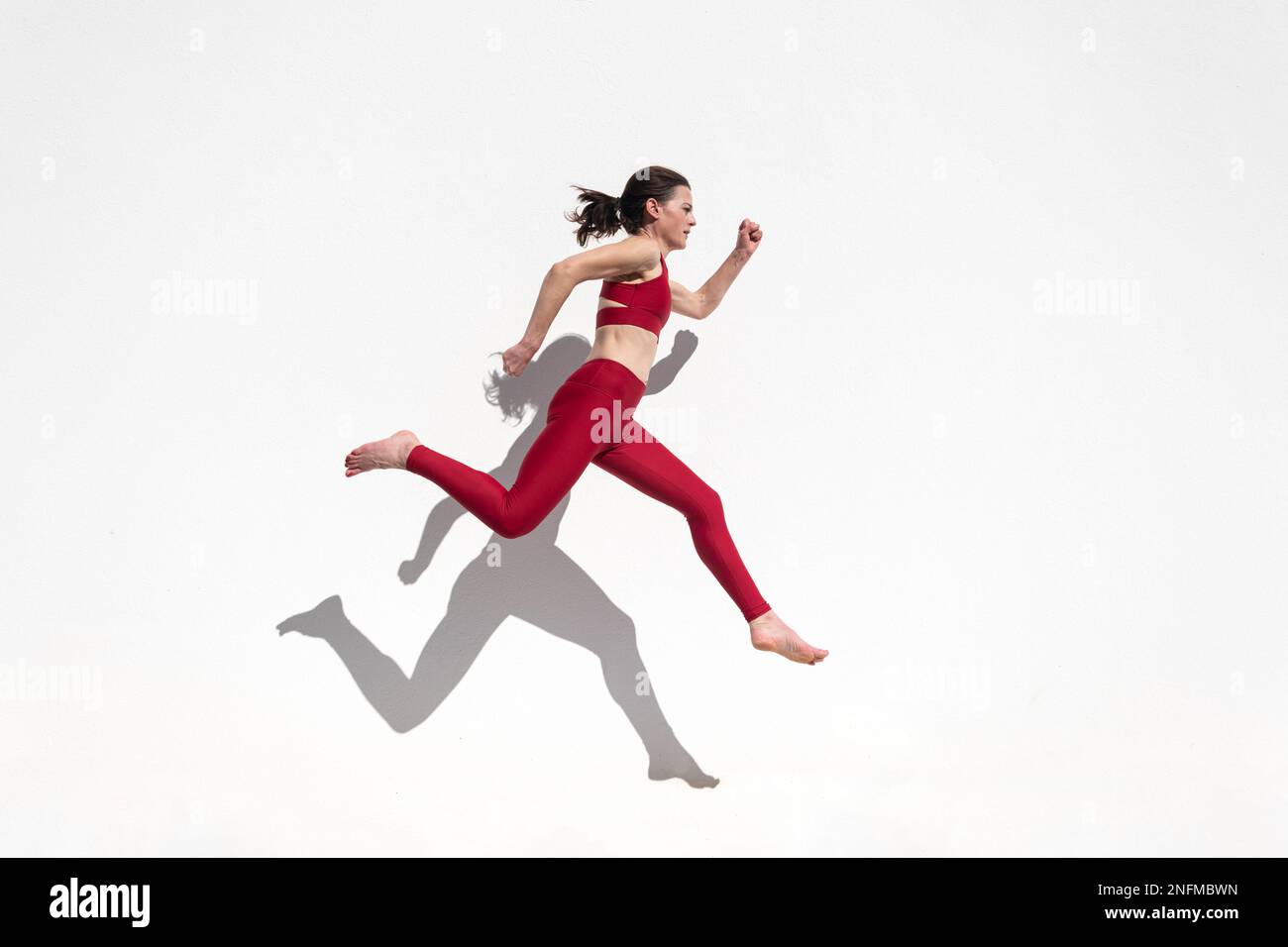 Sporty woman running and jumping Stock Photo