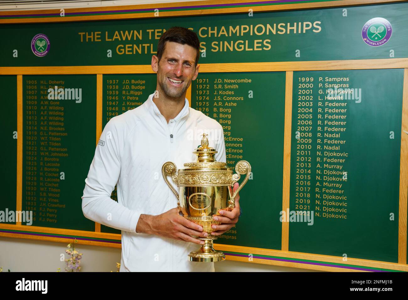 Mens Singles Champion Novak Djokovic with the winners trophy by the Champions board at the 2022