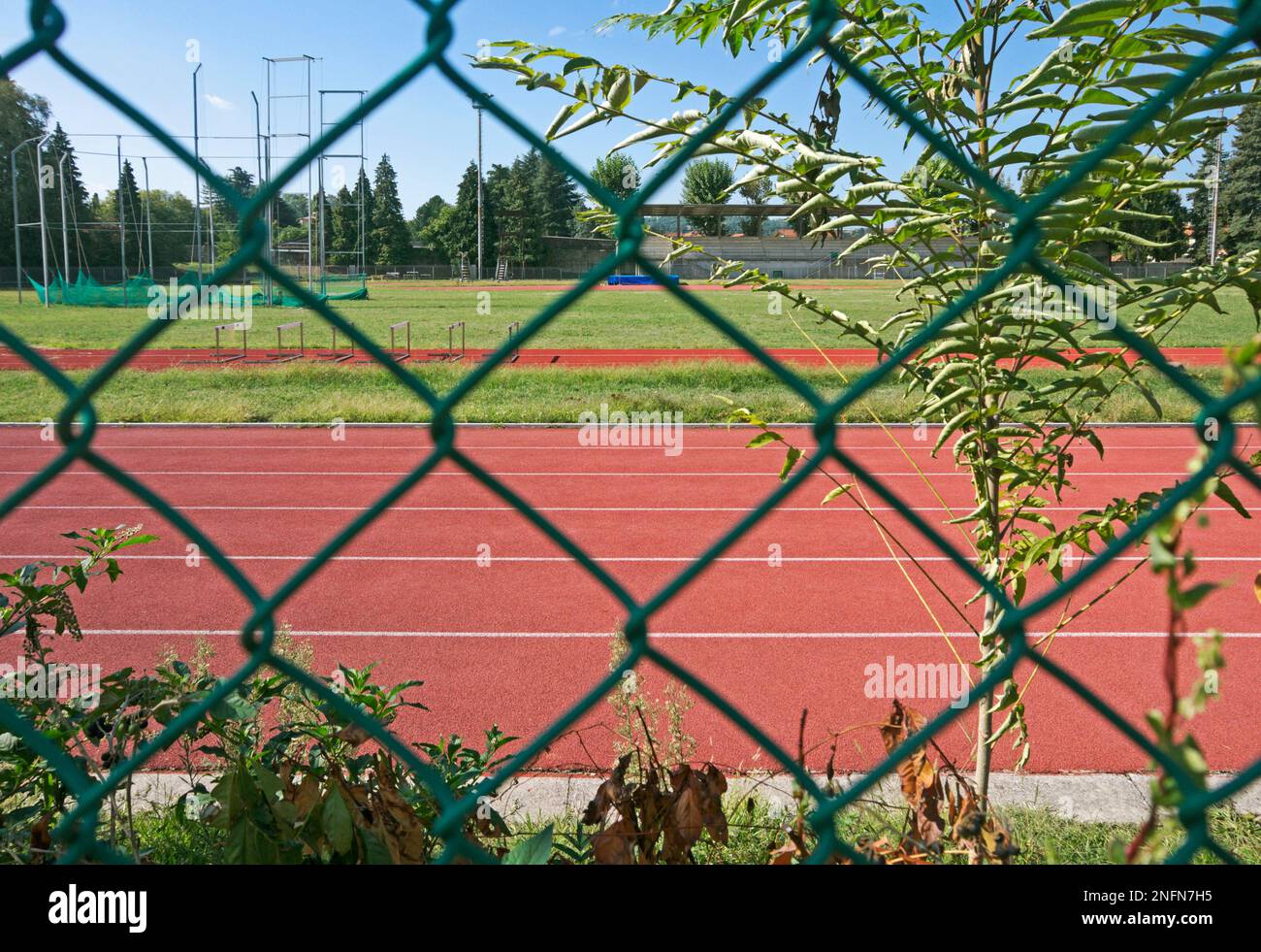 athletic track field through a fencing net Stock Photo