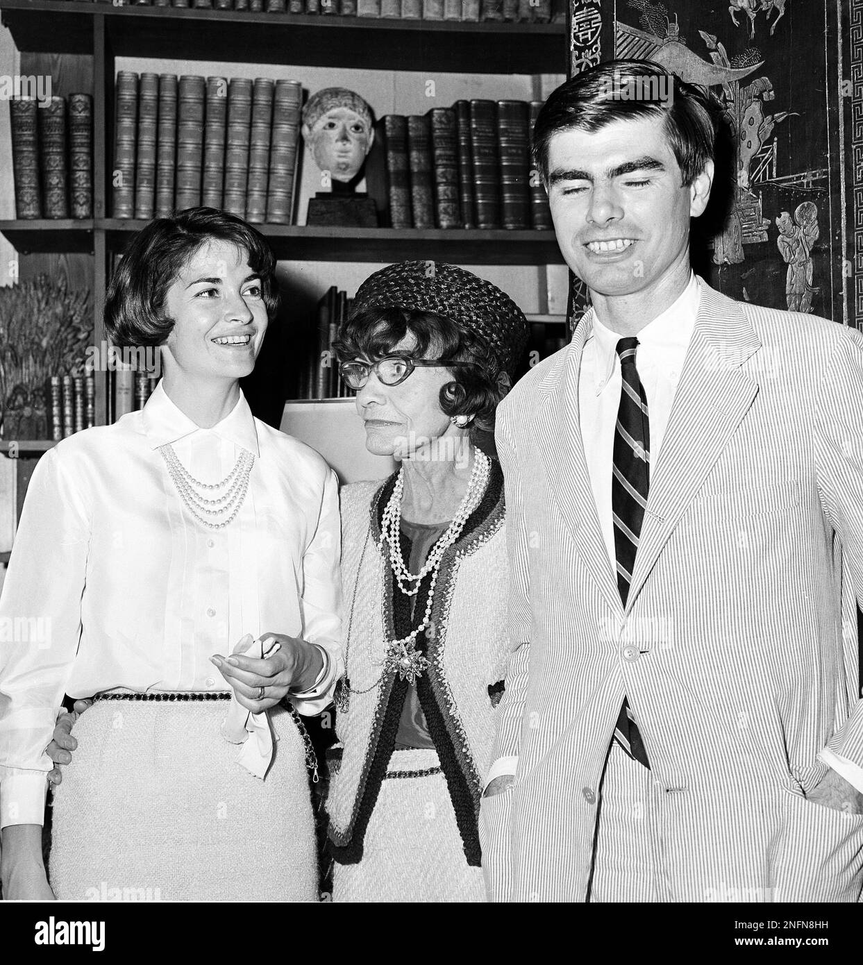 French fashion designer Coco Chanel, center, is shown with Women's Wear  Daily correspondent James Brady and his wife in Paris, July 30, 1964, at  the opening of her fall and winter collection. (