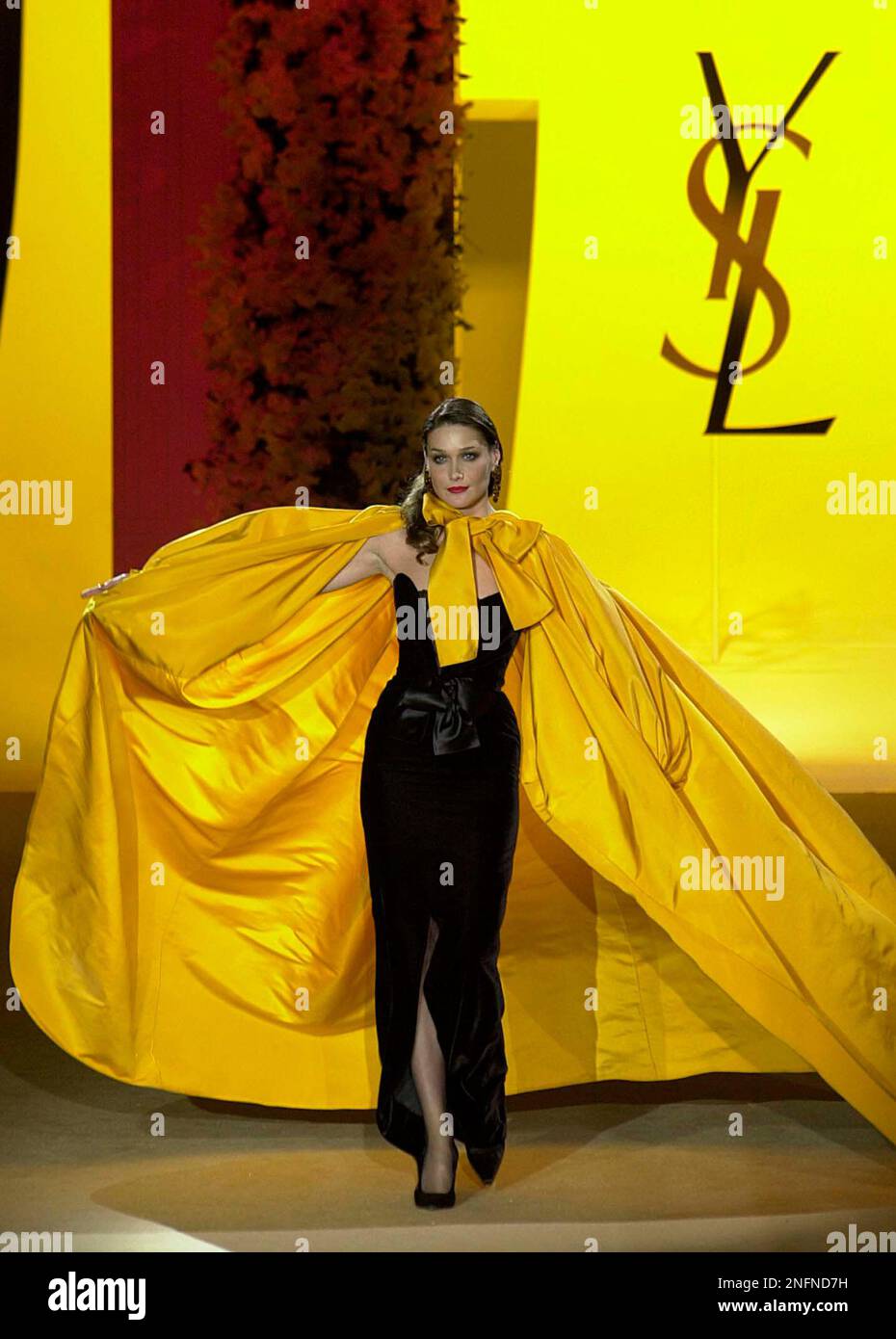 FILE** This Jan. 22, 2002 file photo shows model Carla Bruni as she opens a  long yellow cape to show off a fitted black dress during French legendary  fashion designer Yves Saint