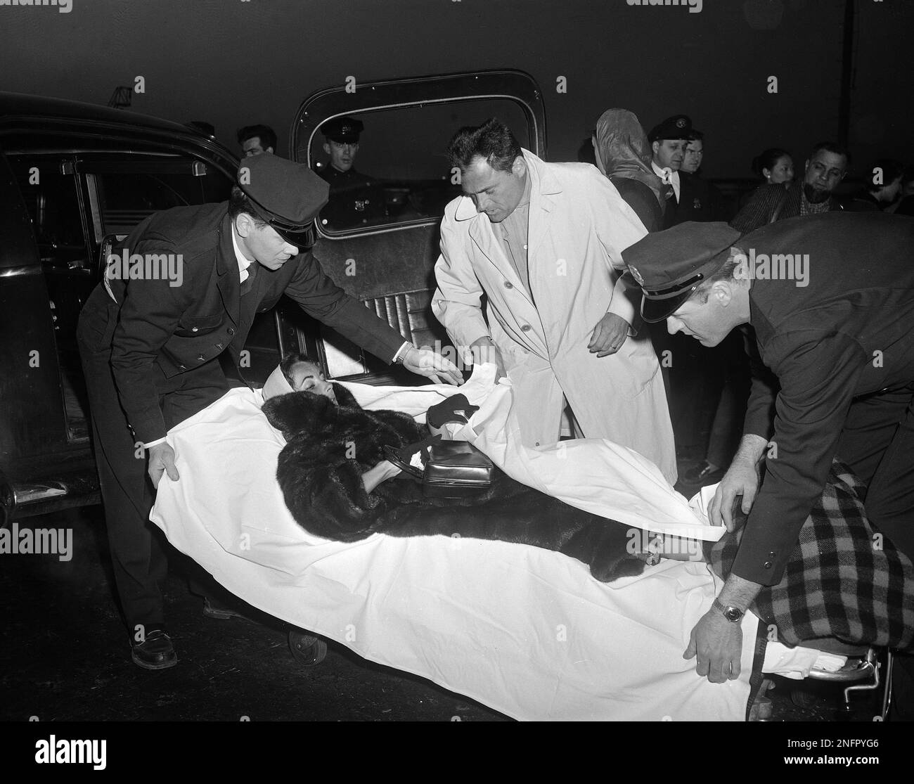 Actress Elizabeth Taylor is placed in a stretcher on her arrival from