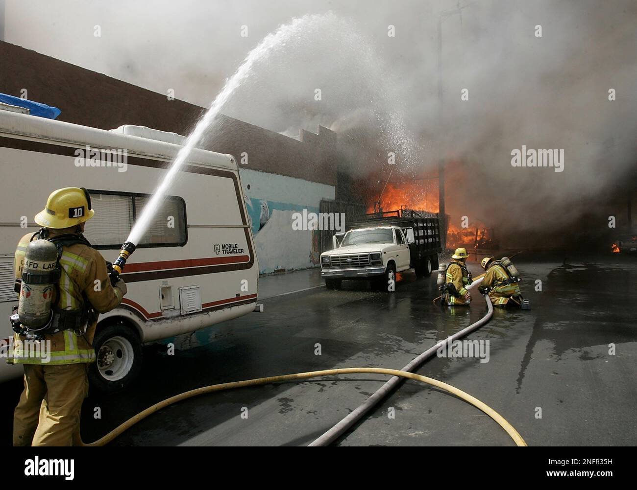 Los Angeles City Firefighters battle a blaze in a row of commercial and ...
