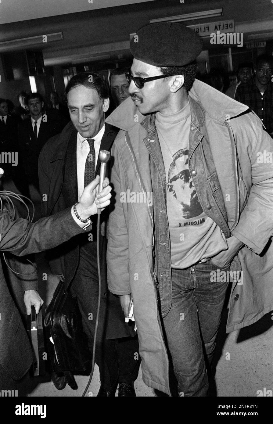H. Rap Brown, wearing a black beret and a Malcolm X shirt, arrives Feb. 21,  1968 in New Orleans with his attorney William Kunstler, right, to face  charges he violated rules of