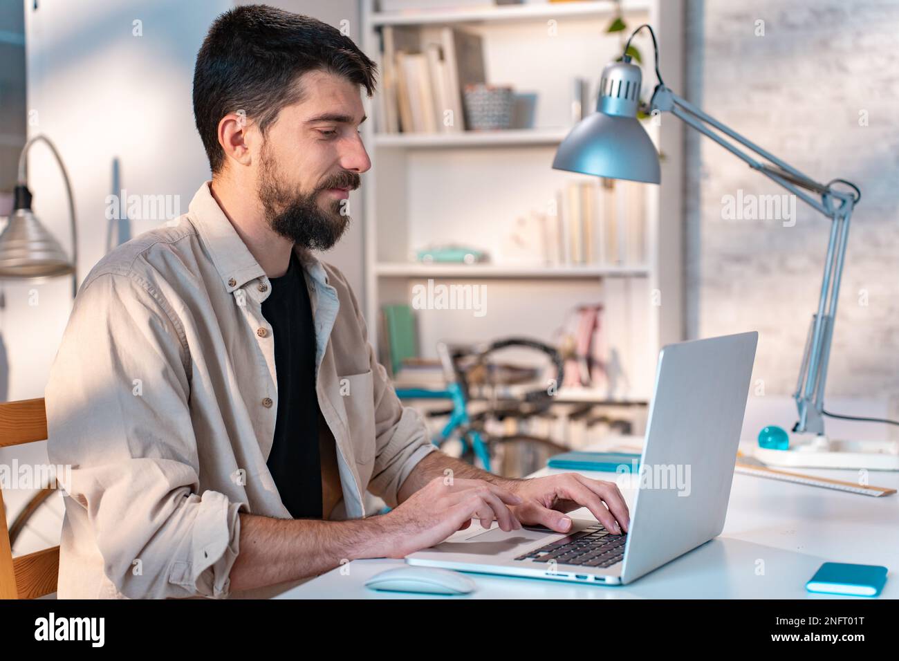 Young man student using laptop computer at home studying online.  Stock Photo