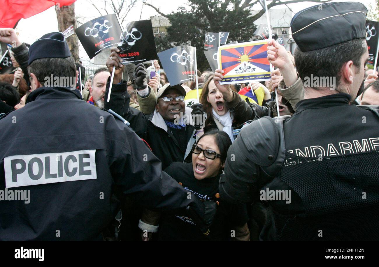 Protestors shout at the Olympic torch, unseen, during the torch relay ...
