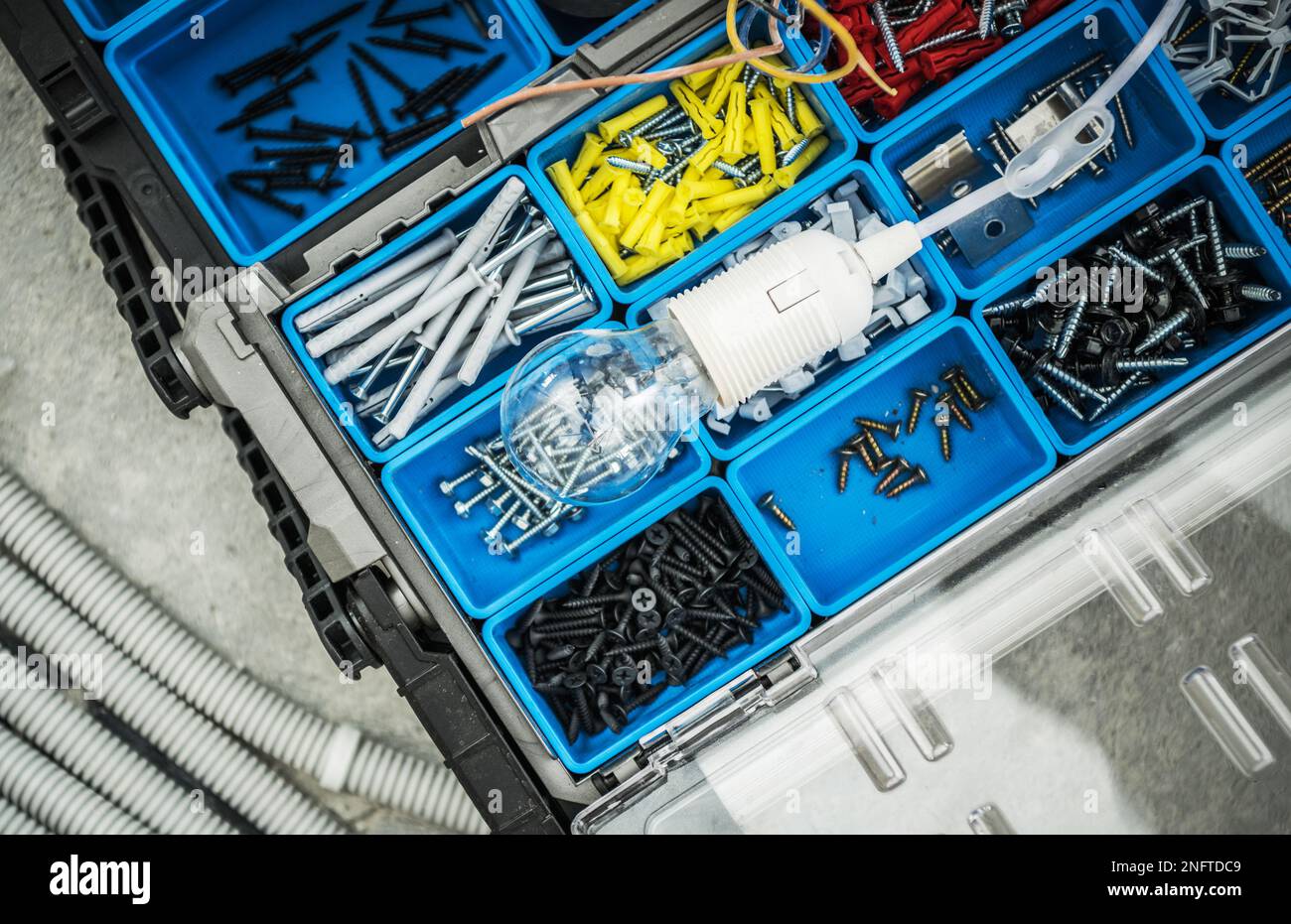 Top View Closeup of Professional Electrician's Toolbox with Screws, Bolts and Dowels for Lighting Installation. Stock Photo